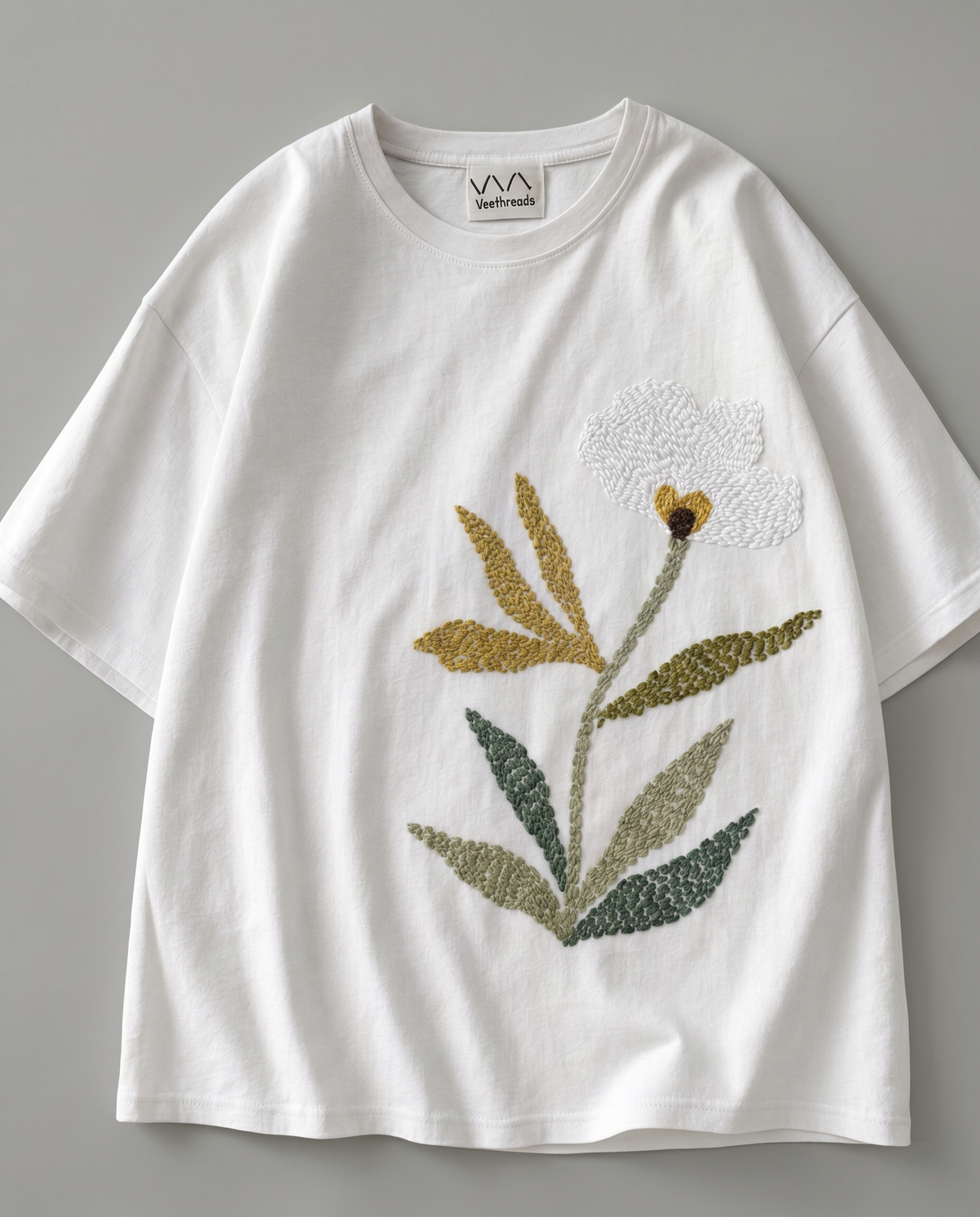 New embroidery design for men's shirts - a large botanical bloom hand-stitched across a white cotton tee
