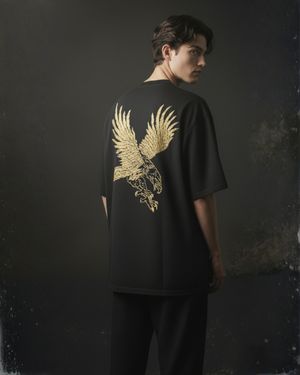 Man wearing a black t-shirt with a gold eagle design embroidered on the back against a dark background