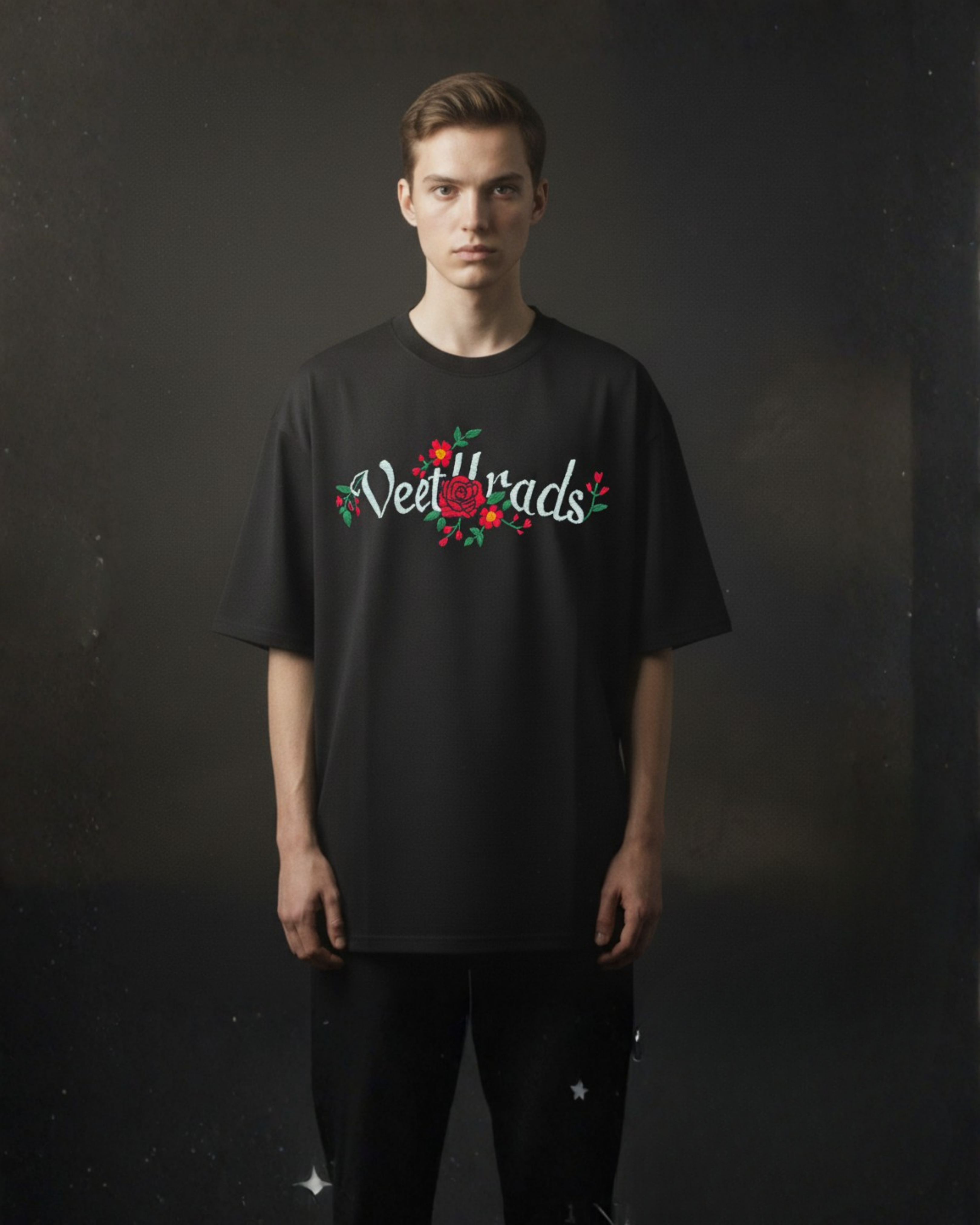Person wearing a black t-shirt with 'Veet Harads' text embroidered and floral design on a dark background