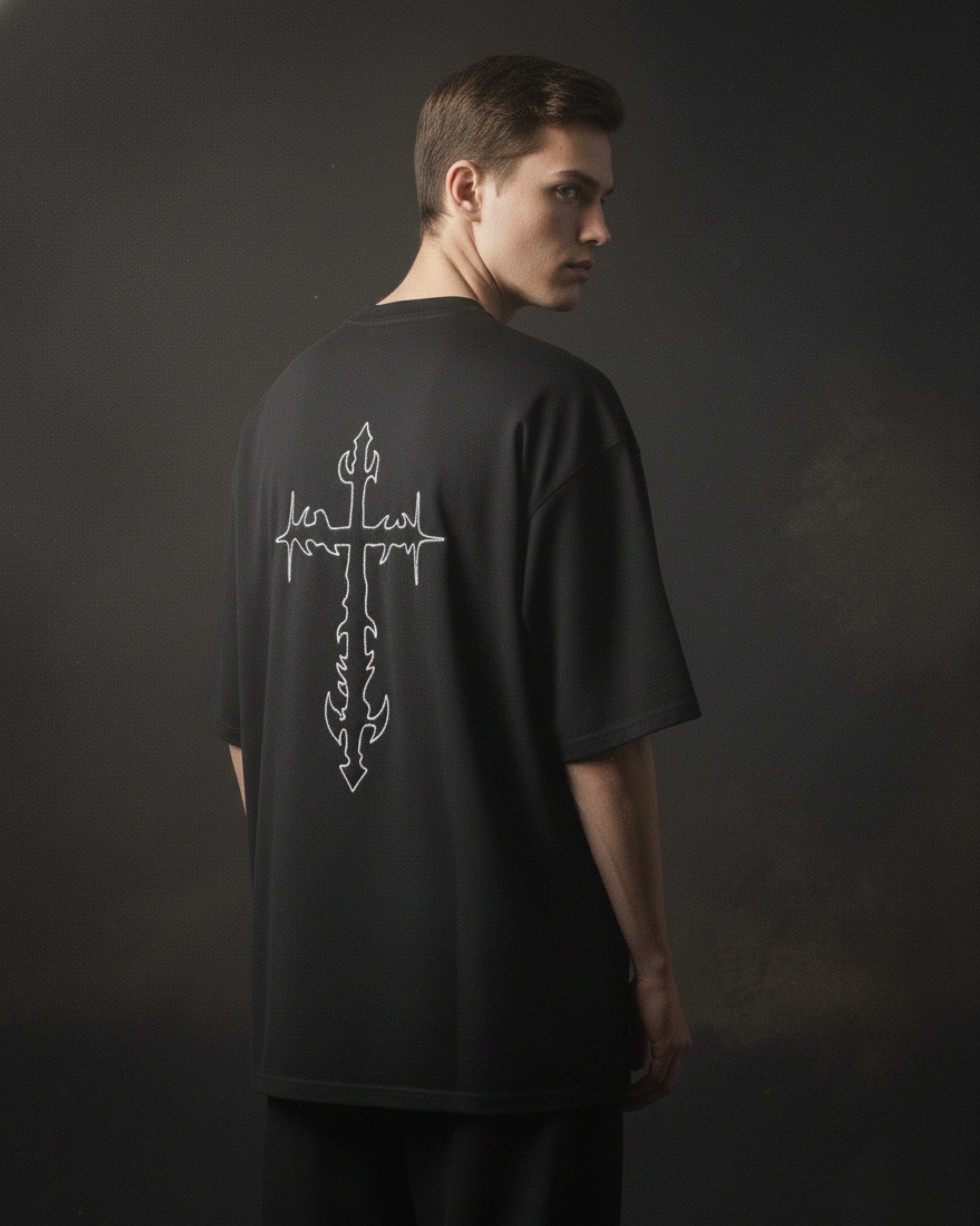 Person wearing a black t-shirt with a white graphic design on the back against a dark background