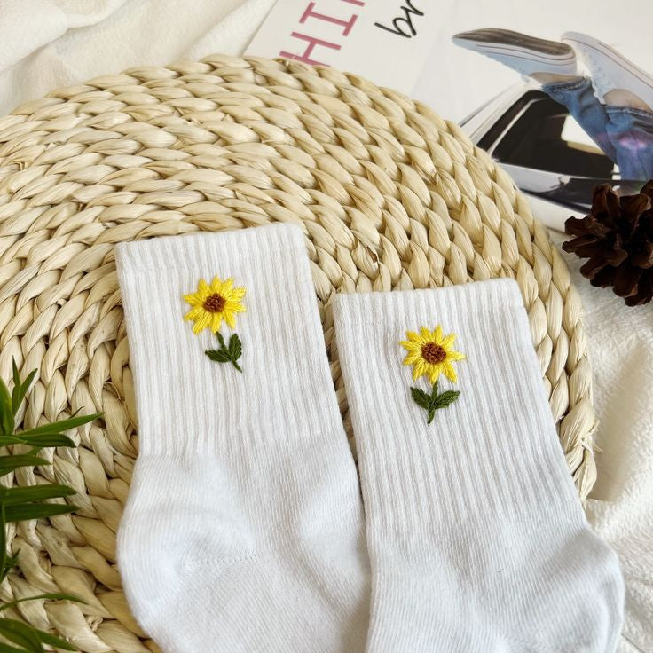 "Pair of floral embroidered socks featuring hand-stitched sunflower