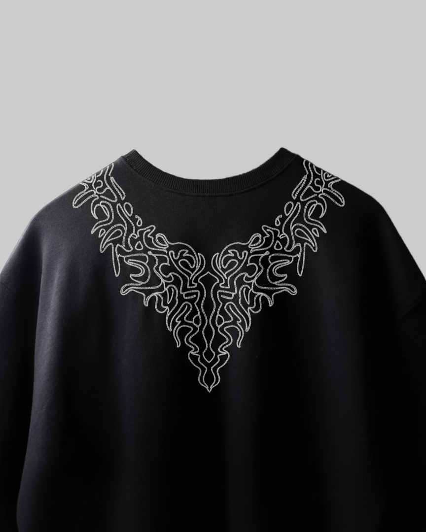 Black tshirt with white intricate design on the back against a black background