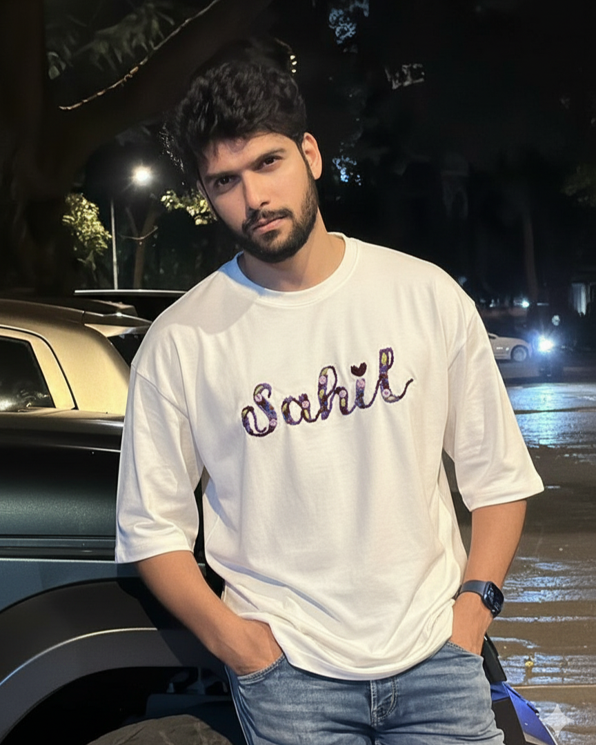 Custom embroidery t shirt purple thread — model wearing white hand-embroidered cotton tee with custom name in purple shades, oversized fit