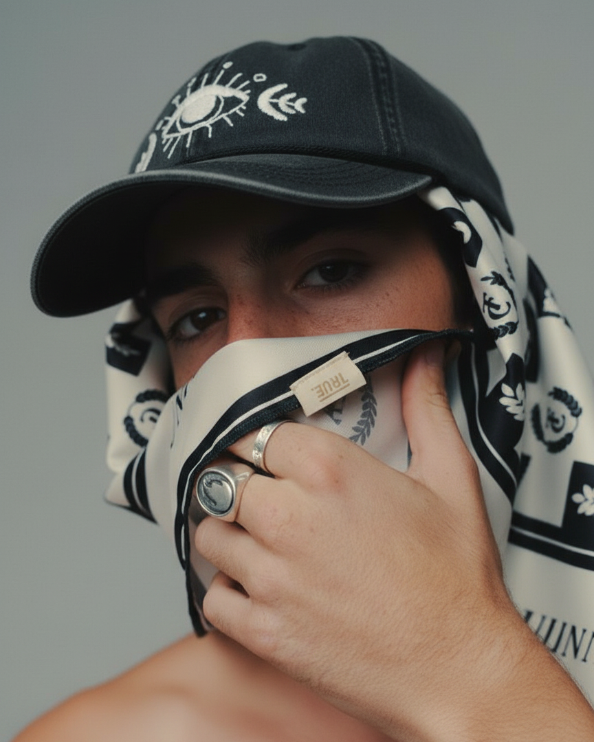Person wearing a black cap with evil eye embroidered