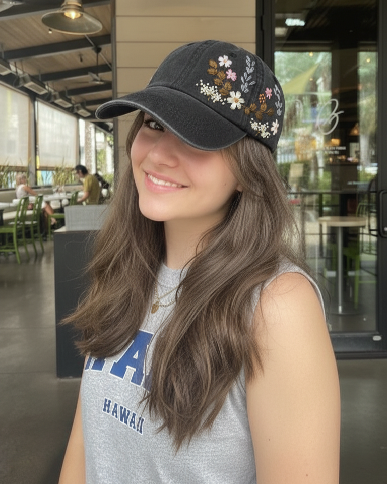 Woman wearing a floral embroidered cap in an indoor setting