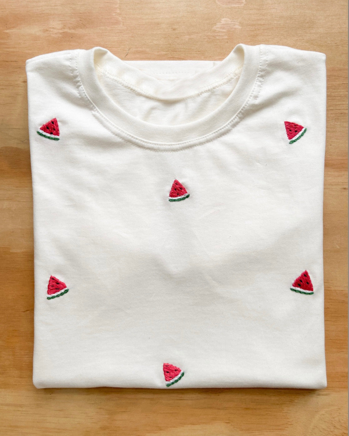 Top view of oversized watermelon embroidered t-shirt made with organic cotto