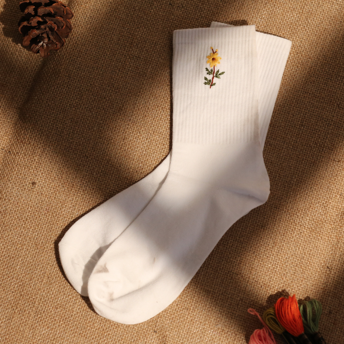 embroidered tiny sunflower sock lying on a bed