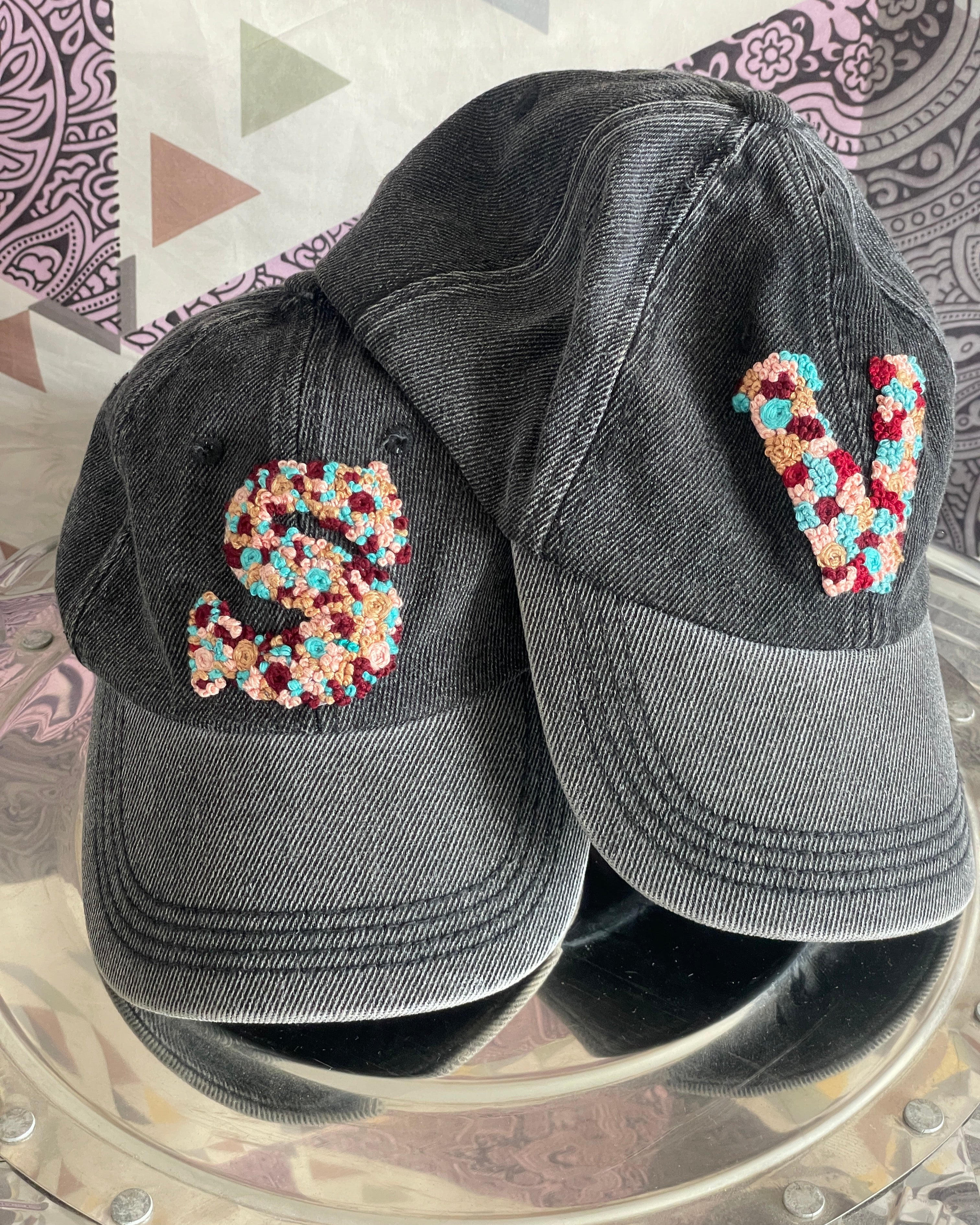 Custom Initials Hand-Embroidered Denim Caps flatlay on a disk