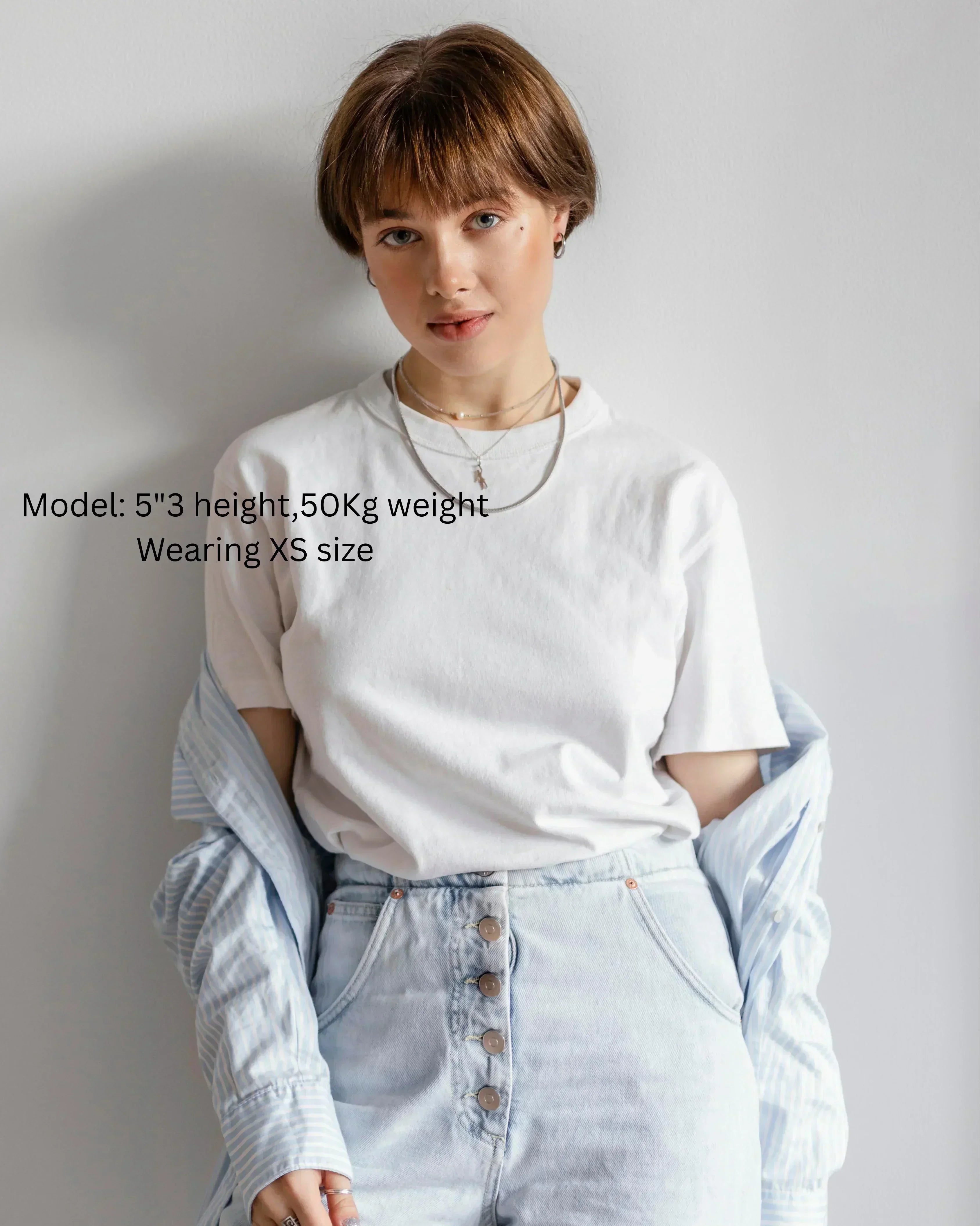 Person wearing a white t-shirt and light blue jeans with text indicating model details.