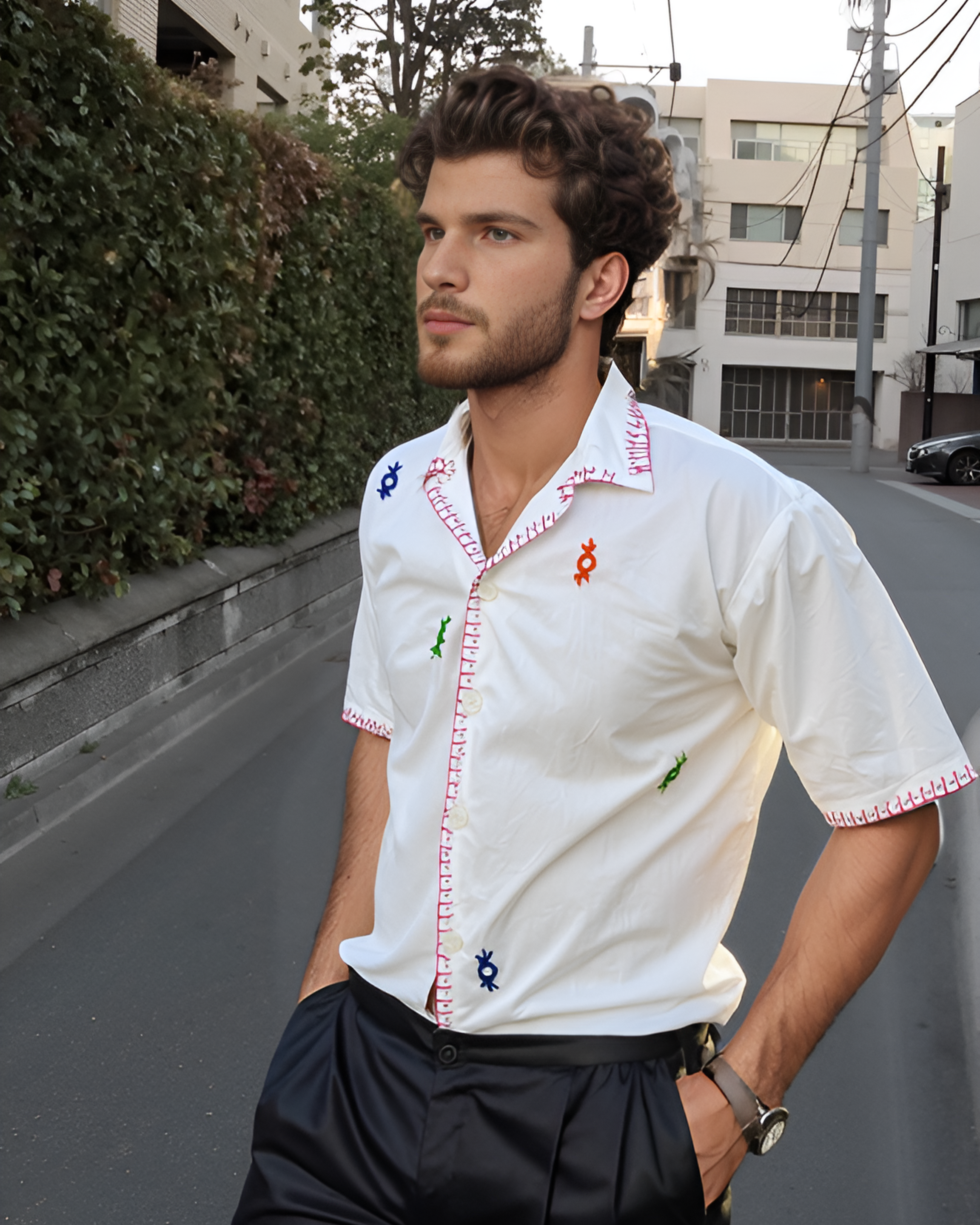 Man wearing a white shirt mirror work cotton shirt with hand-embroidered shisha motifs on a city street.