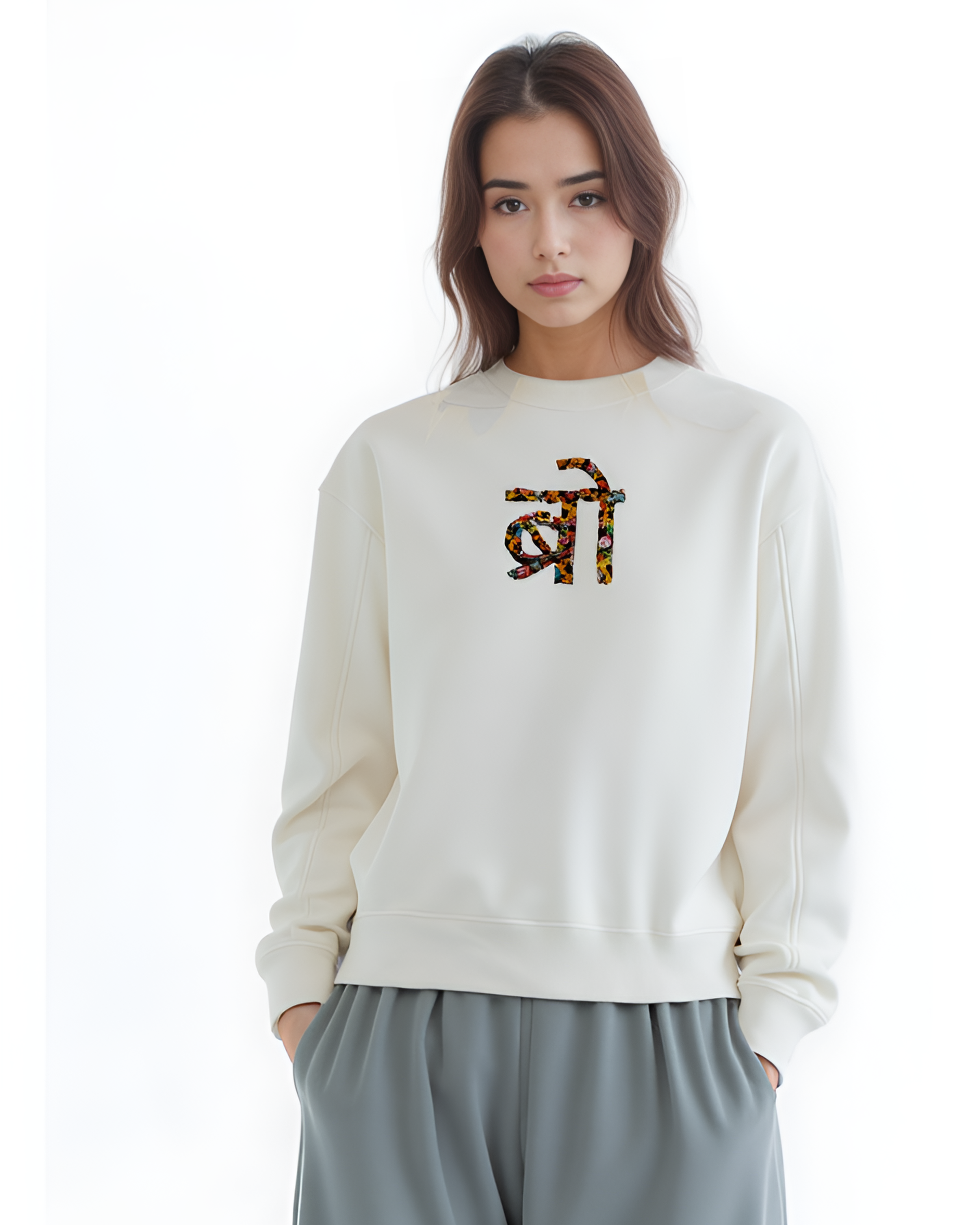 Person wearing cream customised sweatshirt with minimalist name embroidery near the neckline.