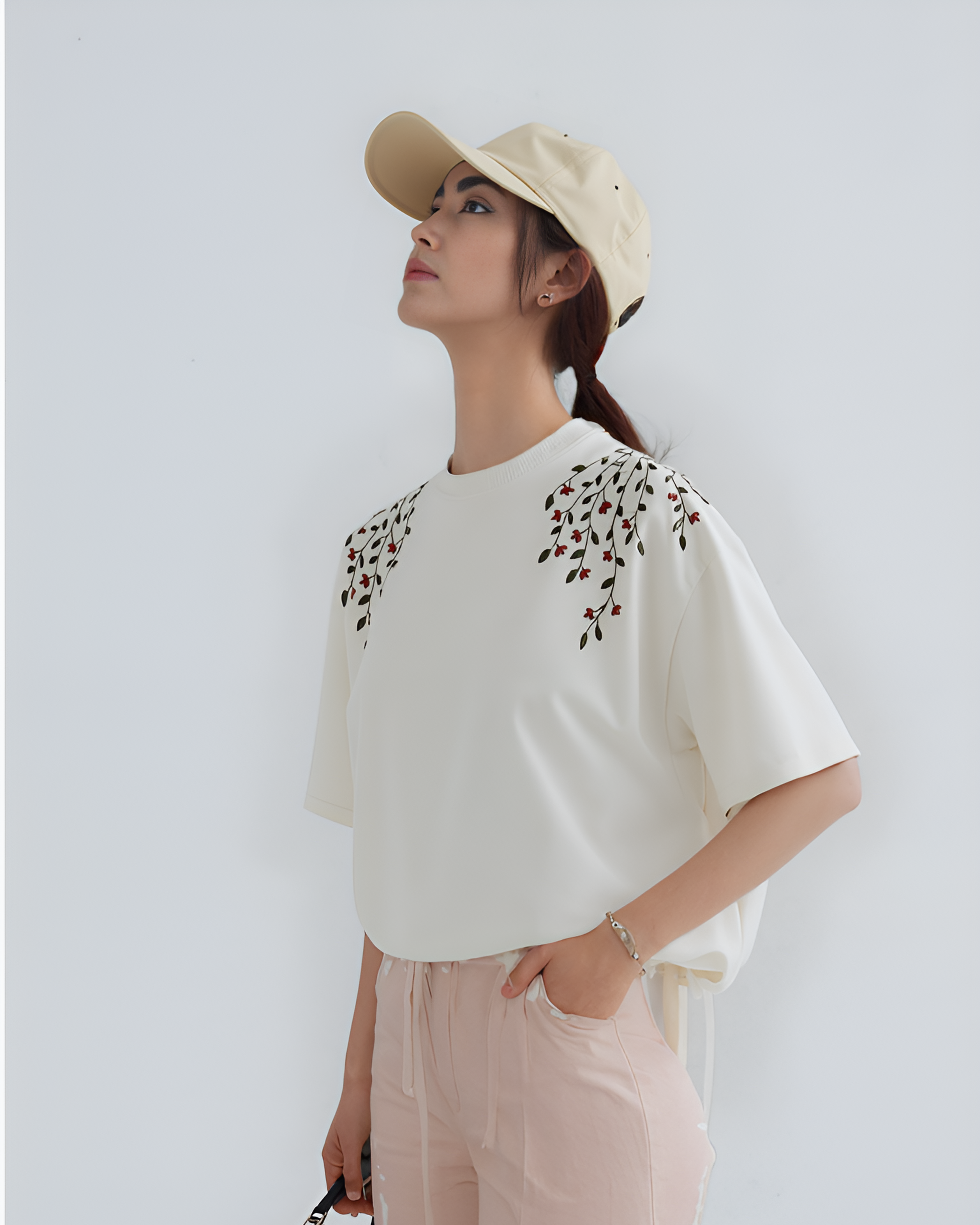Side profile of woman in floral vine embroidery T-shirt, highlighting delicate vines and blooming flower motifs in threadwork.