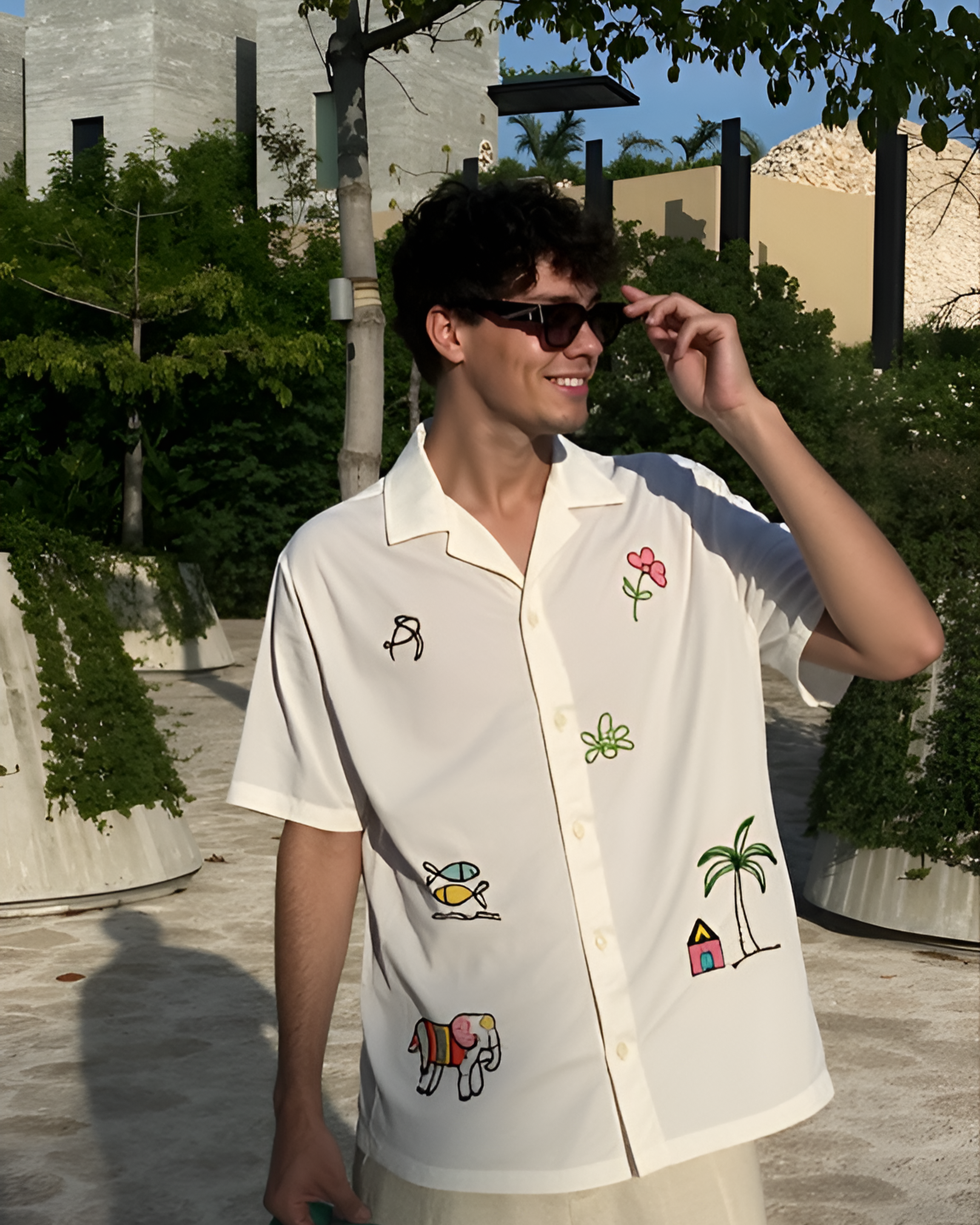 Man wearing a white shirt with colorful beach embroidery designs outdoors