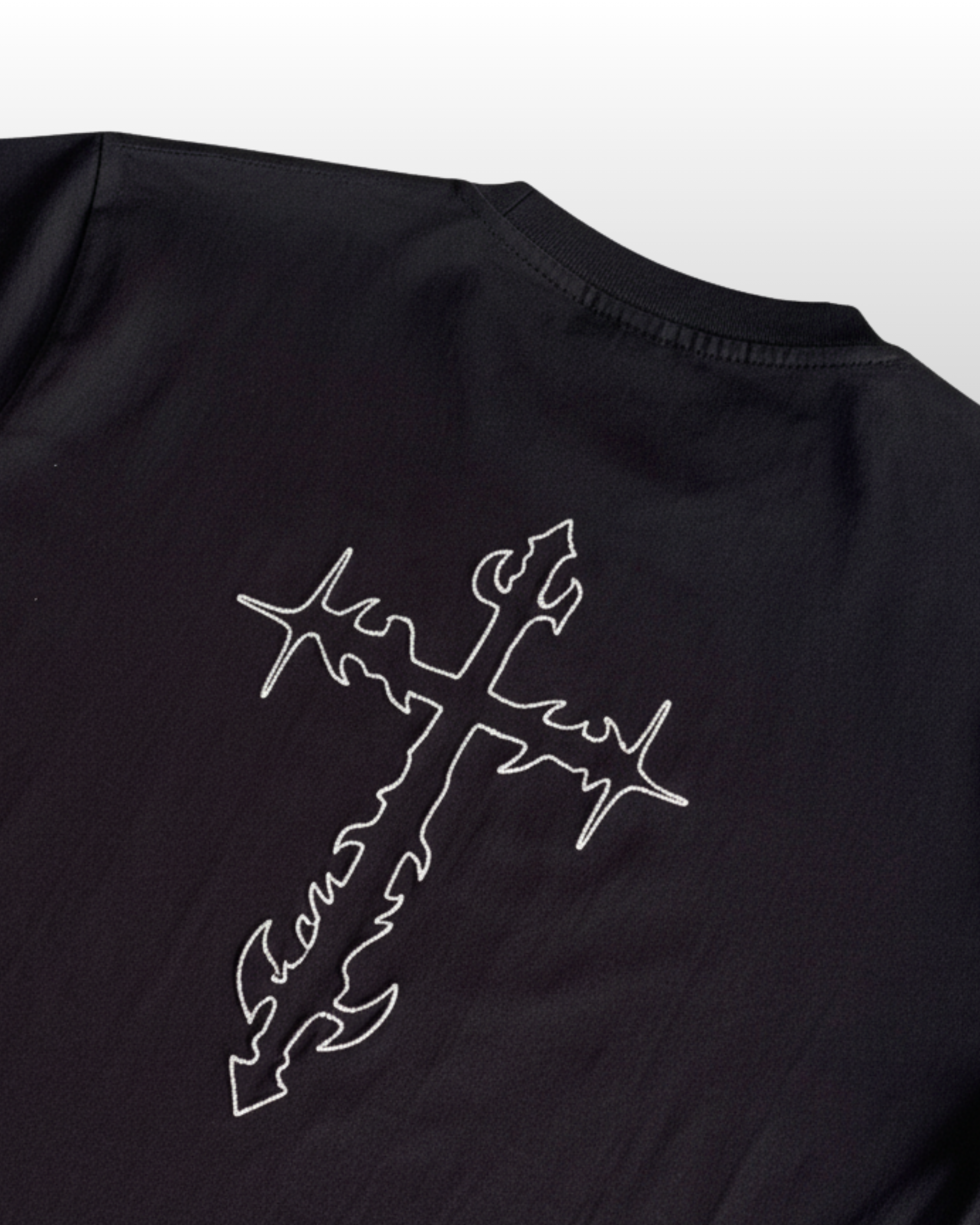 Black t-shirt with a white cross embroidered on a light gray background