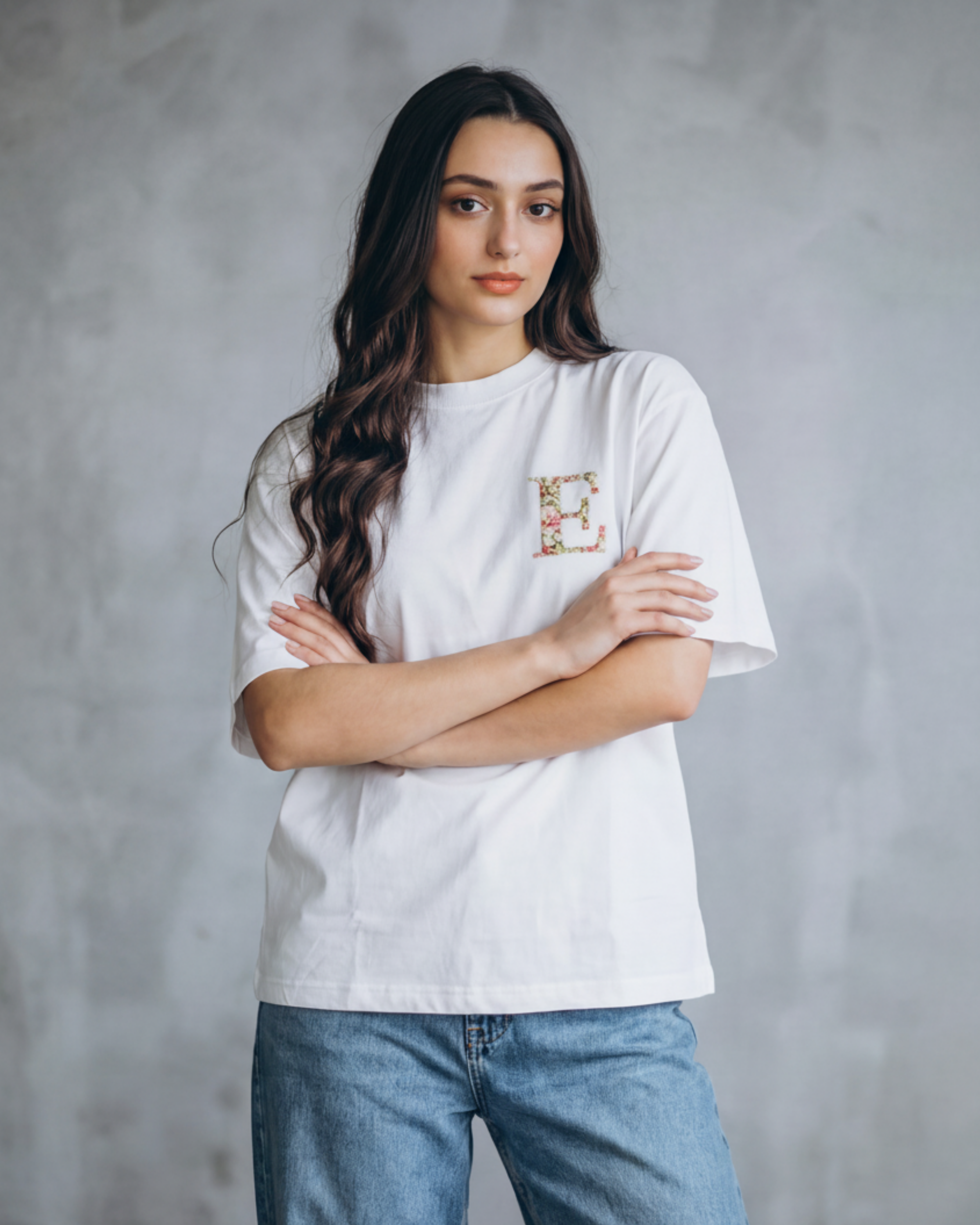 Custom name initials hand-embroidered on a white cotton oversized tee — personalised letters in real thread, made to order.