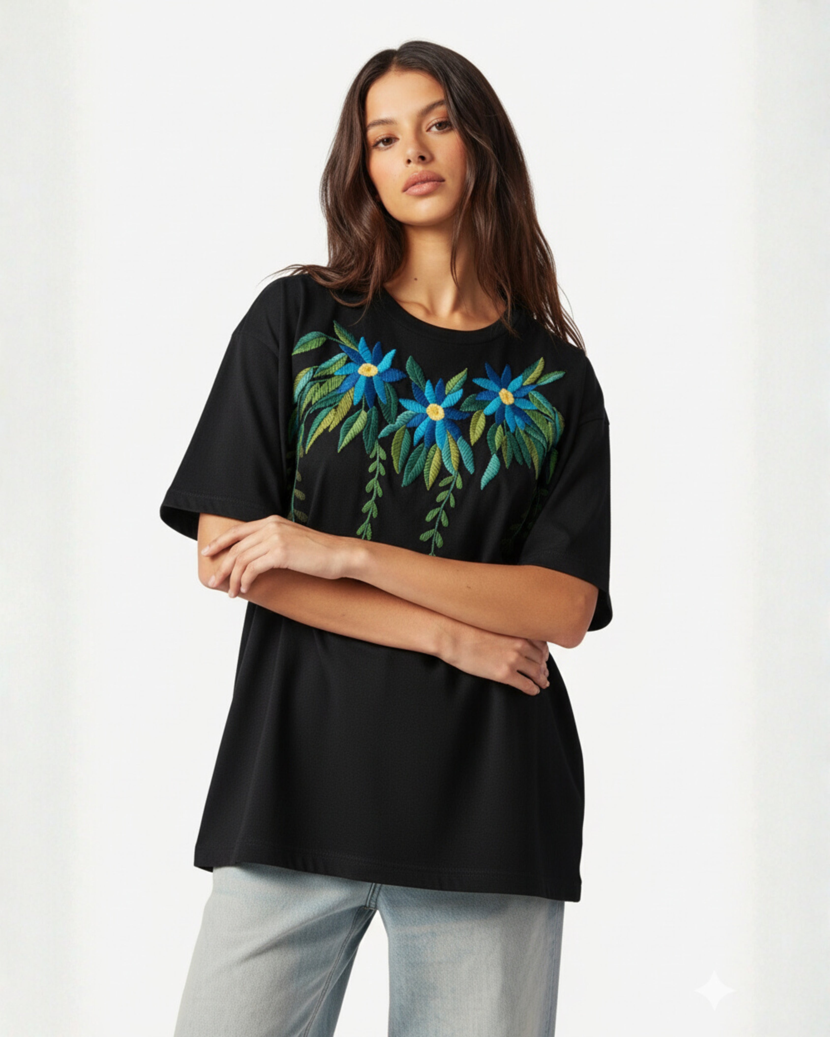 Woman wearing a black t-shirt with hand embroidered floral design on a white background