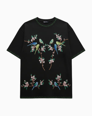Black t-shirt with colorful bird and floral embroidery on a white background