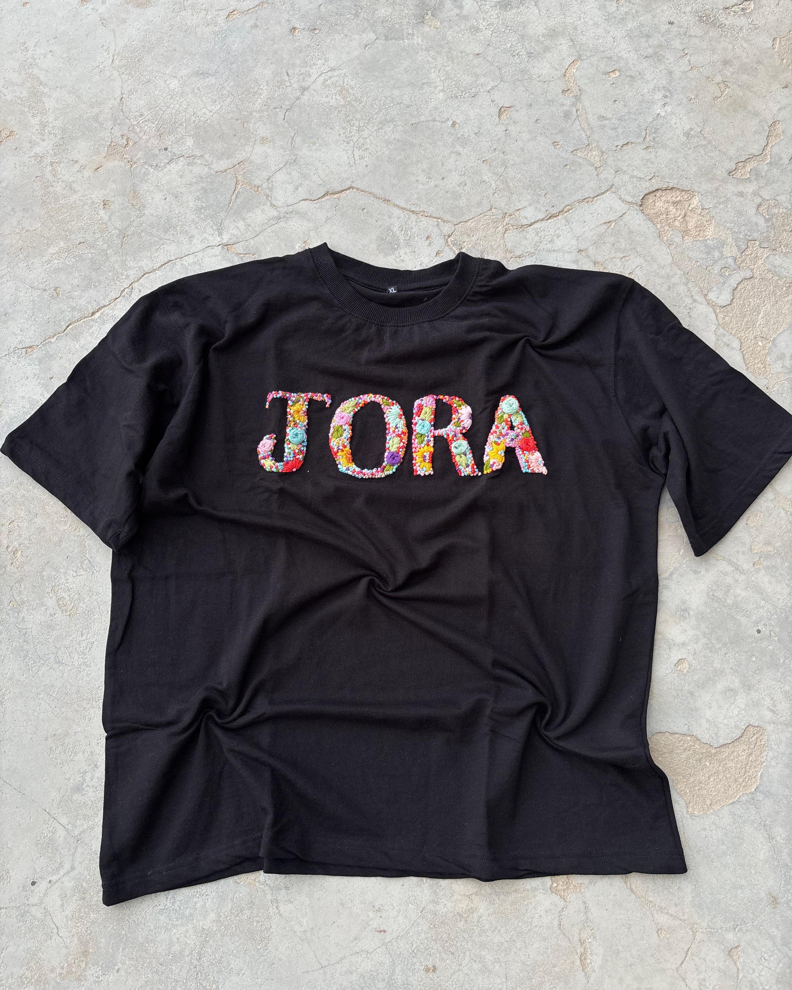 Personalised custom embroidered t-shirt with name initials near neckline, crafted for a clean, aesthetic look