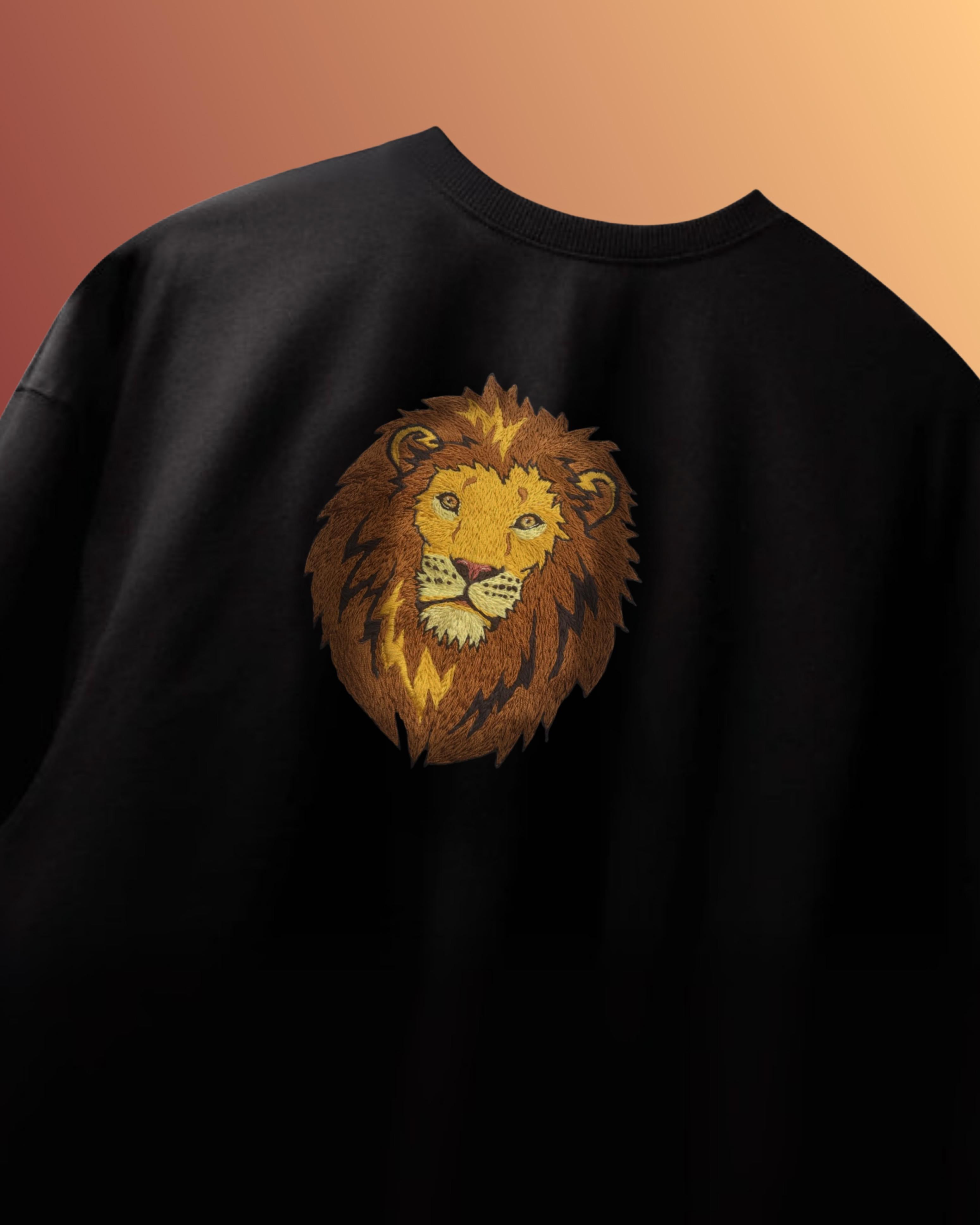 Flat lay of black oversized t-shirt with detailed hand embroidered lion on chest, made from 240 GSM heavyweight cotton – unisex handcrafted apparel.