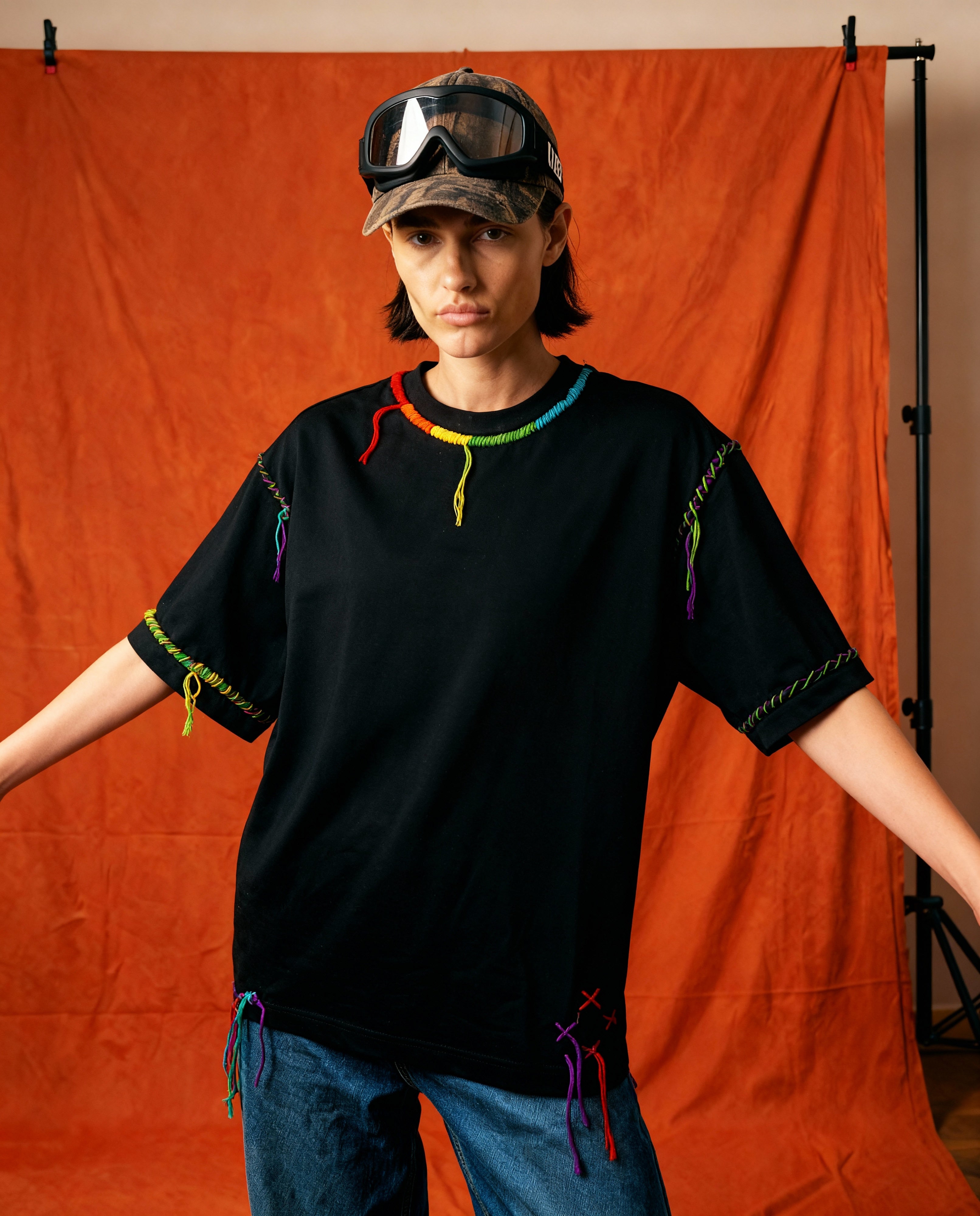 Concepteur kantha tee — black cotton tee with colourful kantha-stitch trim at the neckline, hand-stitched, oversized fit.