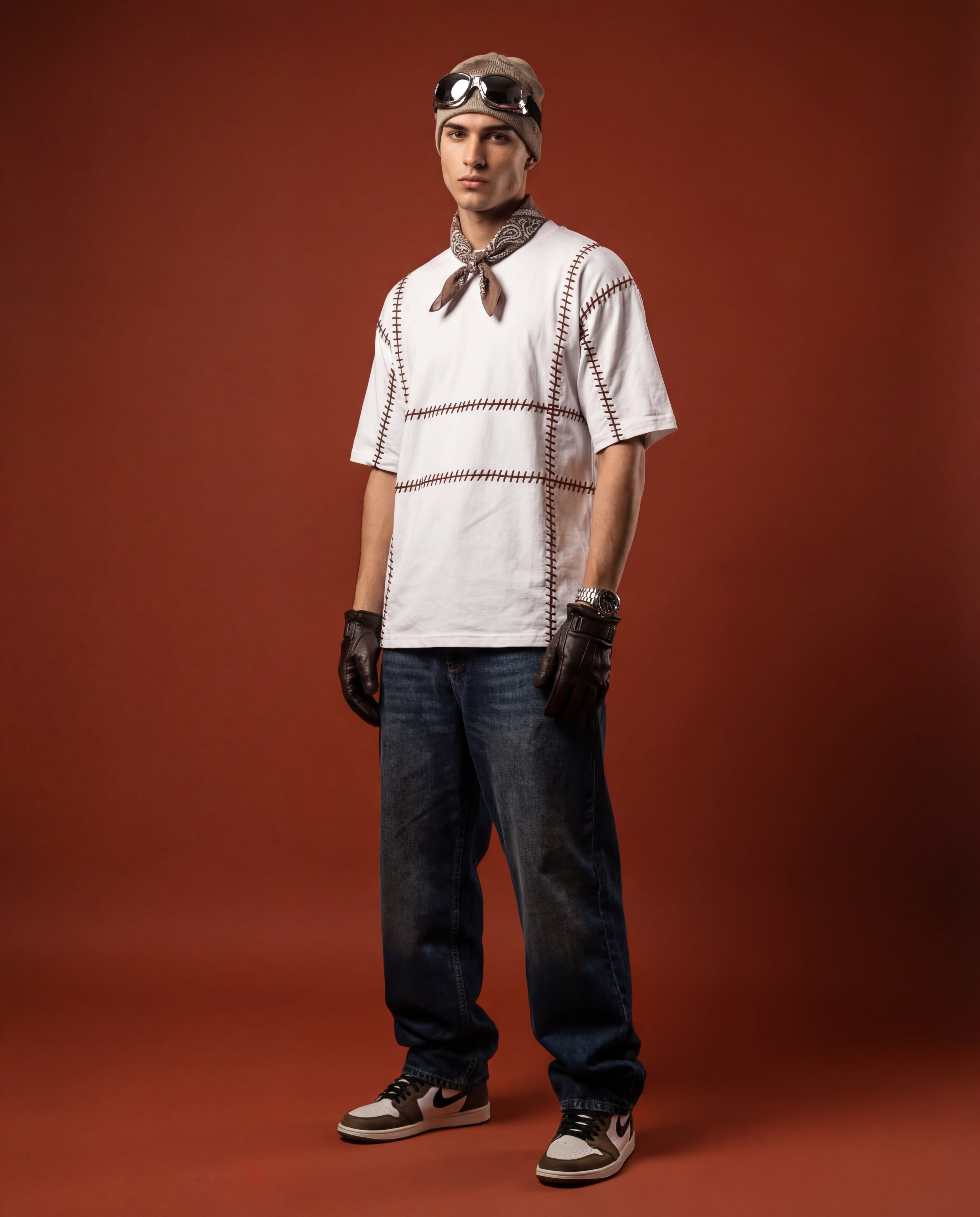 Streetwear embroidered shirt geometric — person wearing white tee with brown grid pattern hand-embroidered, dark jeans, urban styling