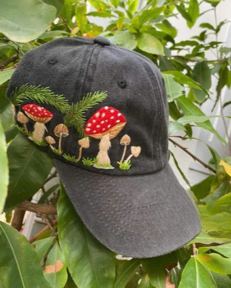 mushroom embroidered acid wash denim cap standing on green leaves