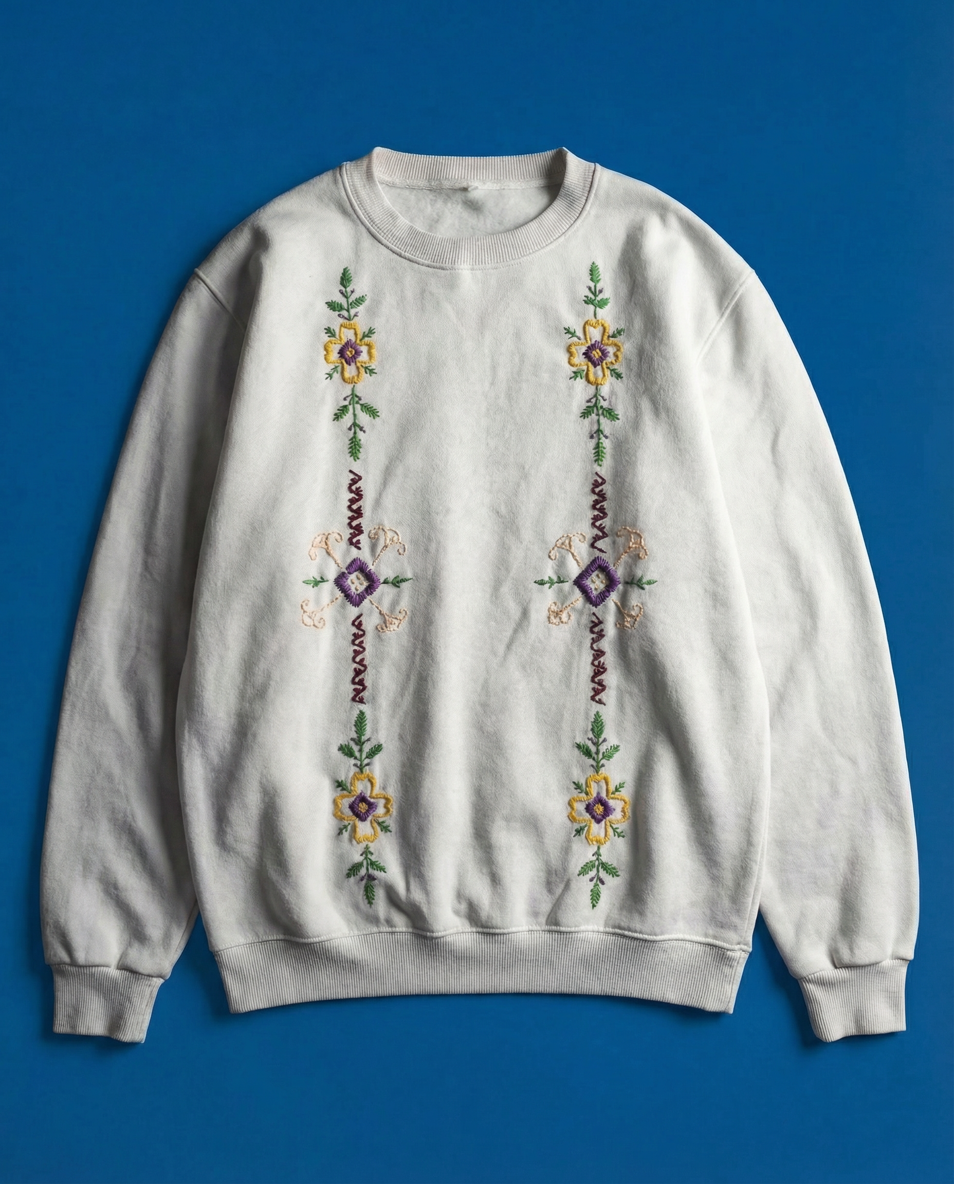 Gray sweatshirt with floral embroidery on a blue background