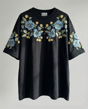 Midnight Garden florals hand-embroidered on a black 220 GSM cotton oversized tee — dark botanical motifs in real thread, oversized unisex fit.