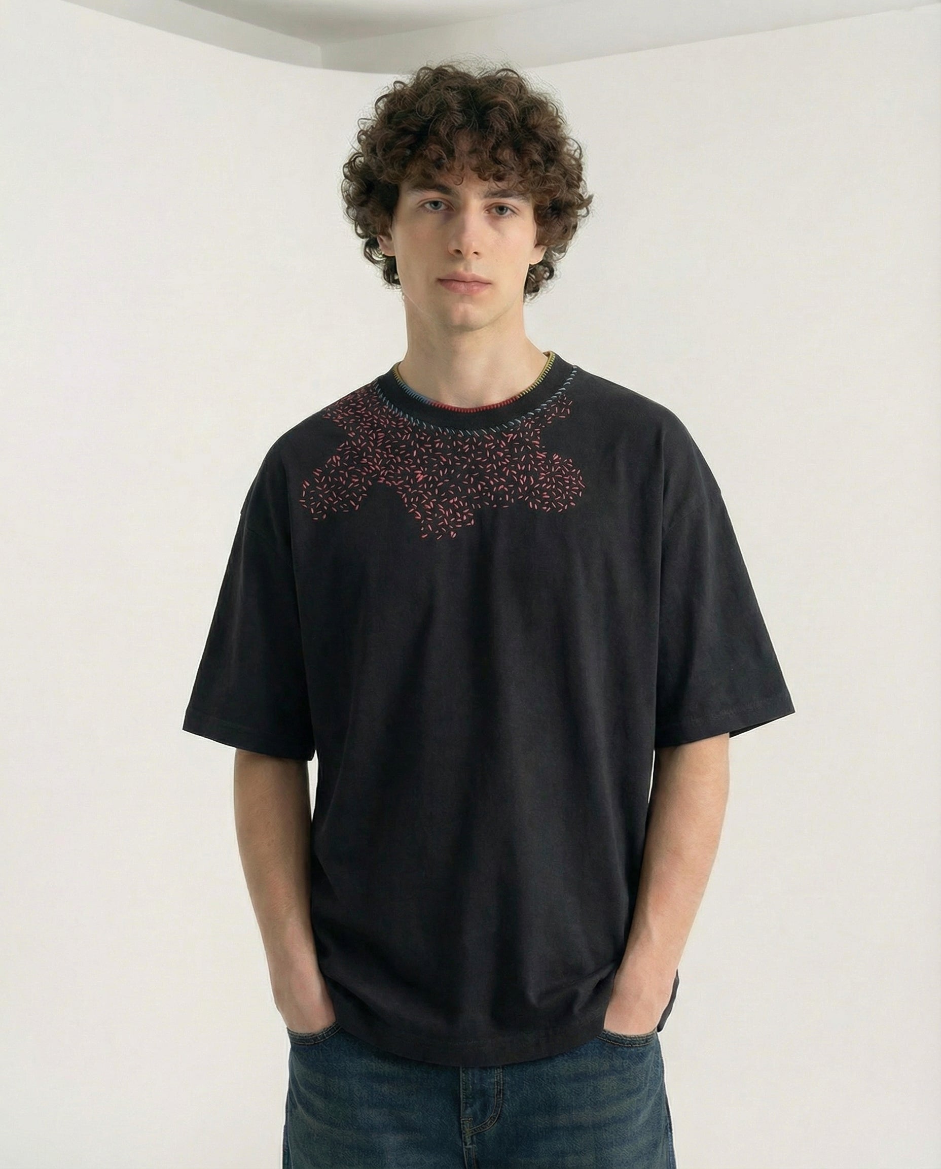 Person wearing a black t-shirt with a red pattern on a white background