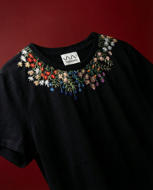 Black t-shirt with floral embroidery on a red background