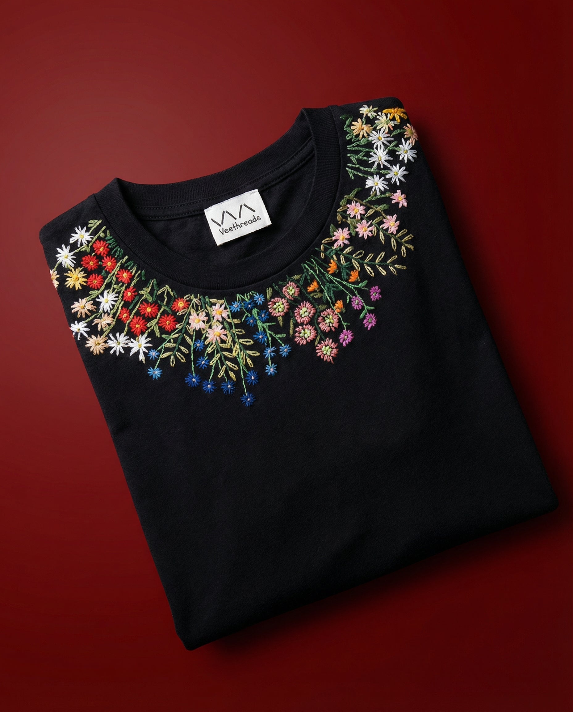 Black shirt with colorful floral embroidery on a red background