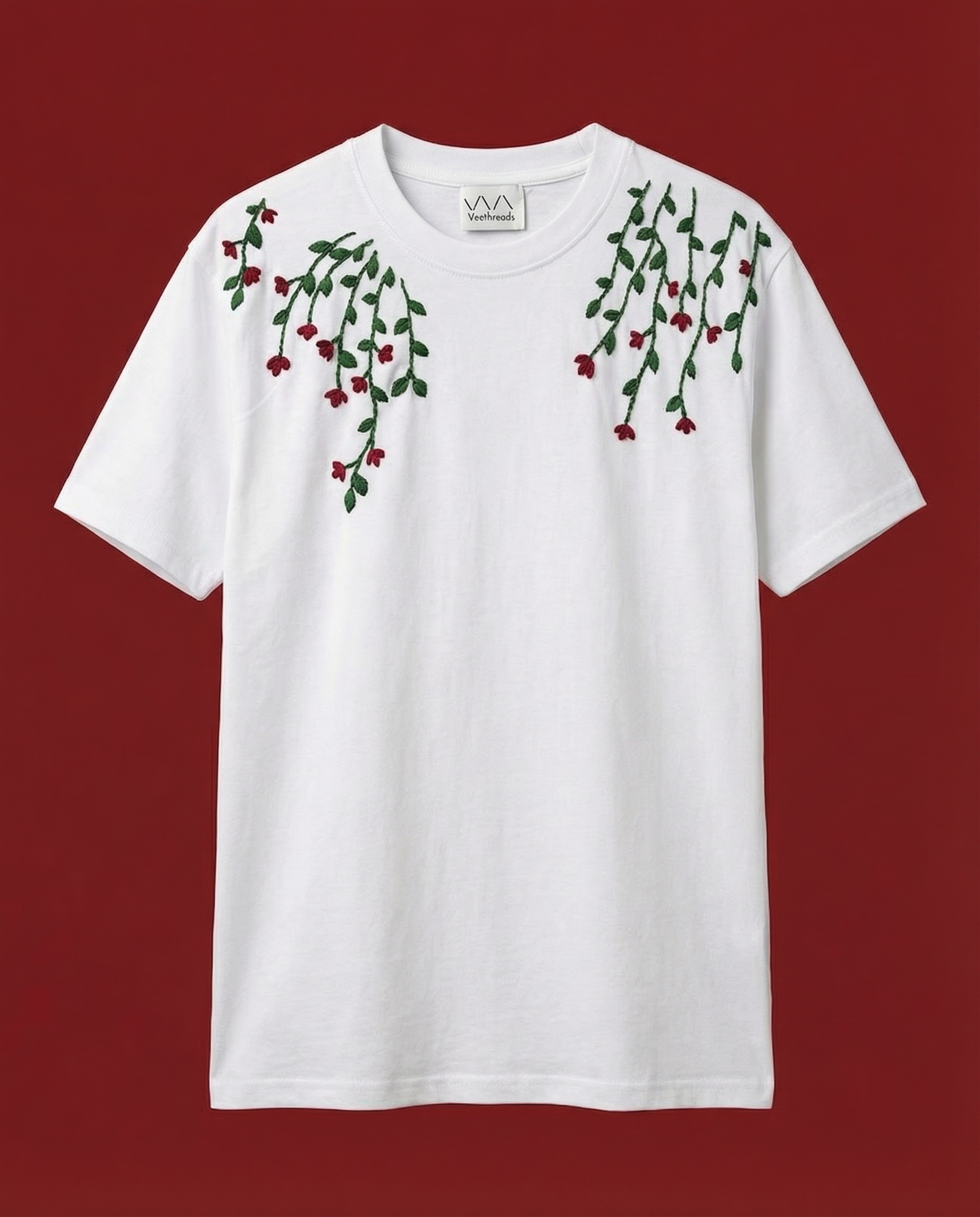 White t-shirt with floral vines designs on a red background