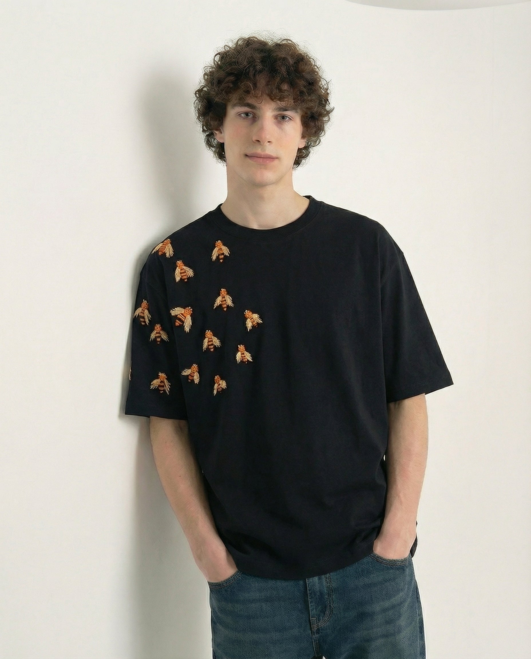 Person wearing a black t-shirt with small patterns against a white background