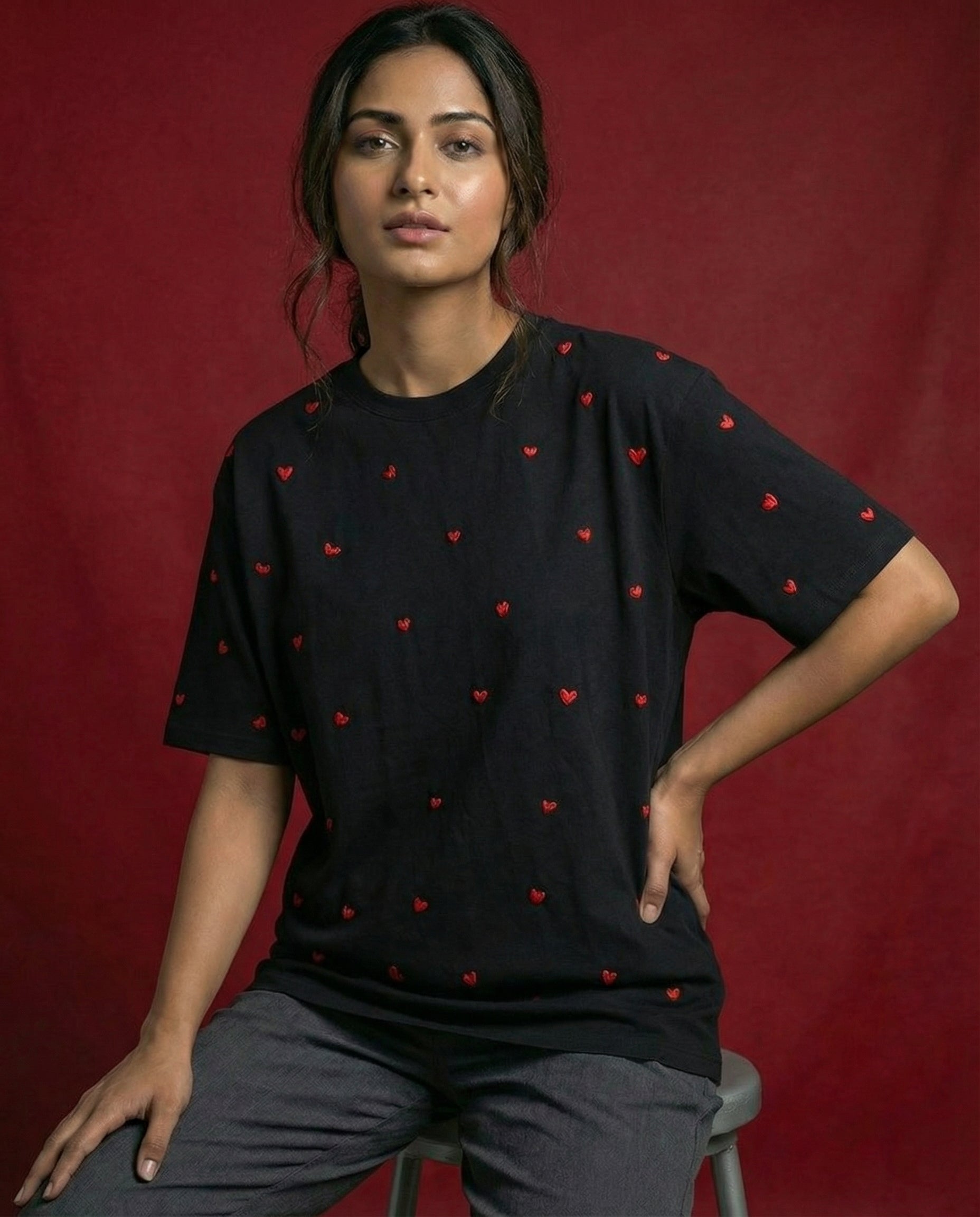 Woman wearing a red heart shirt
white shirt with red heart patterns against a red background