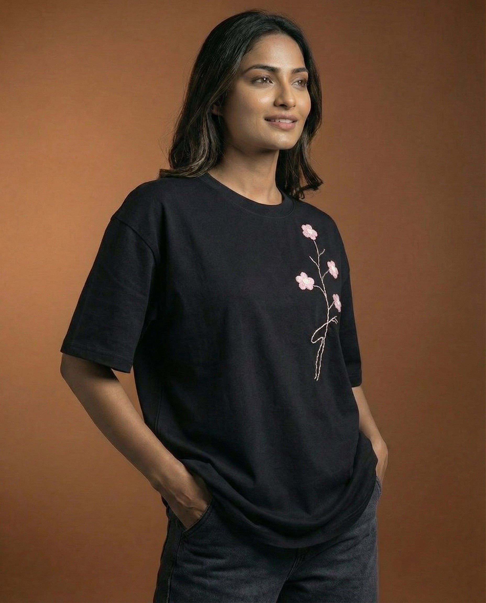 Woman wearing a black t-shirt with a floral design on a brown background