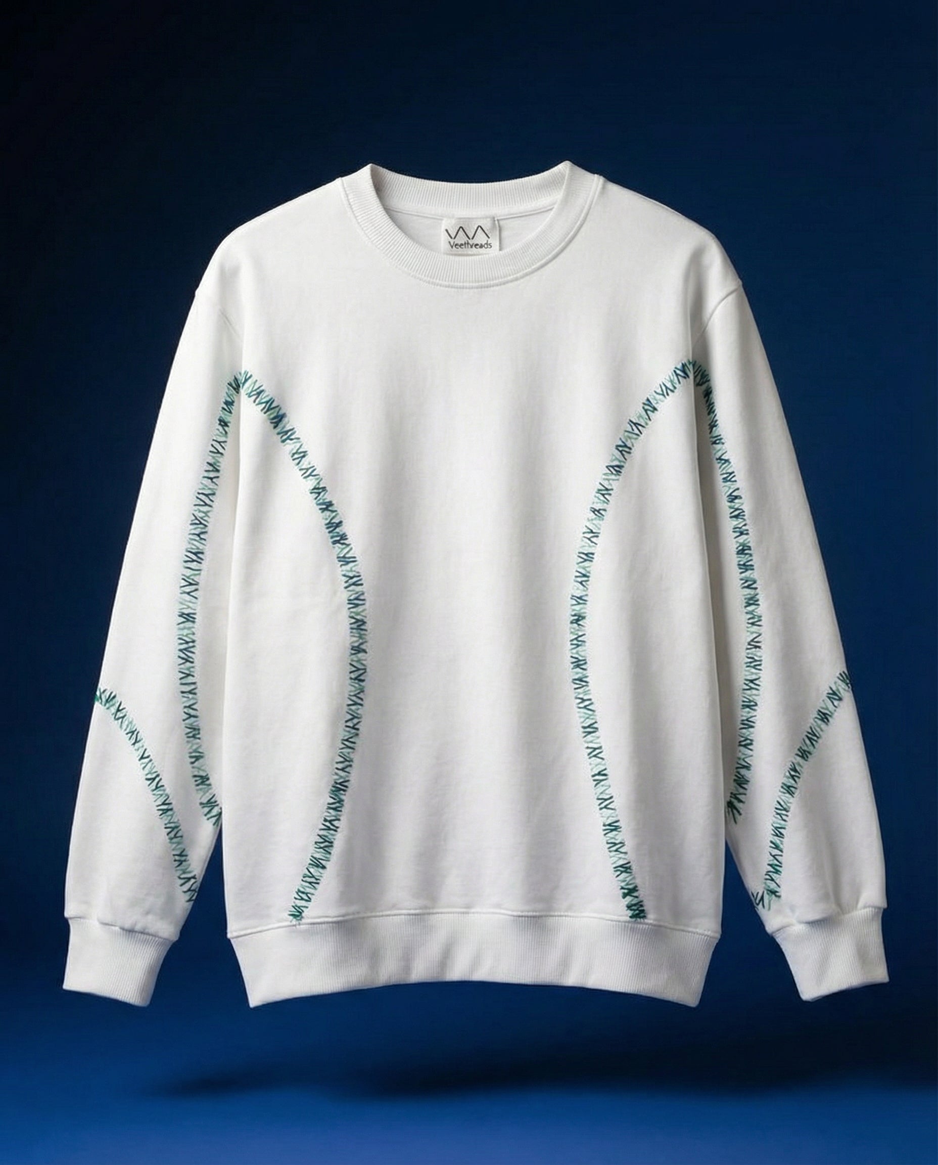White sweatshirt with embroiderey patterns on a blue background