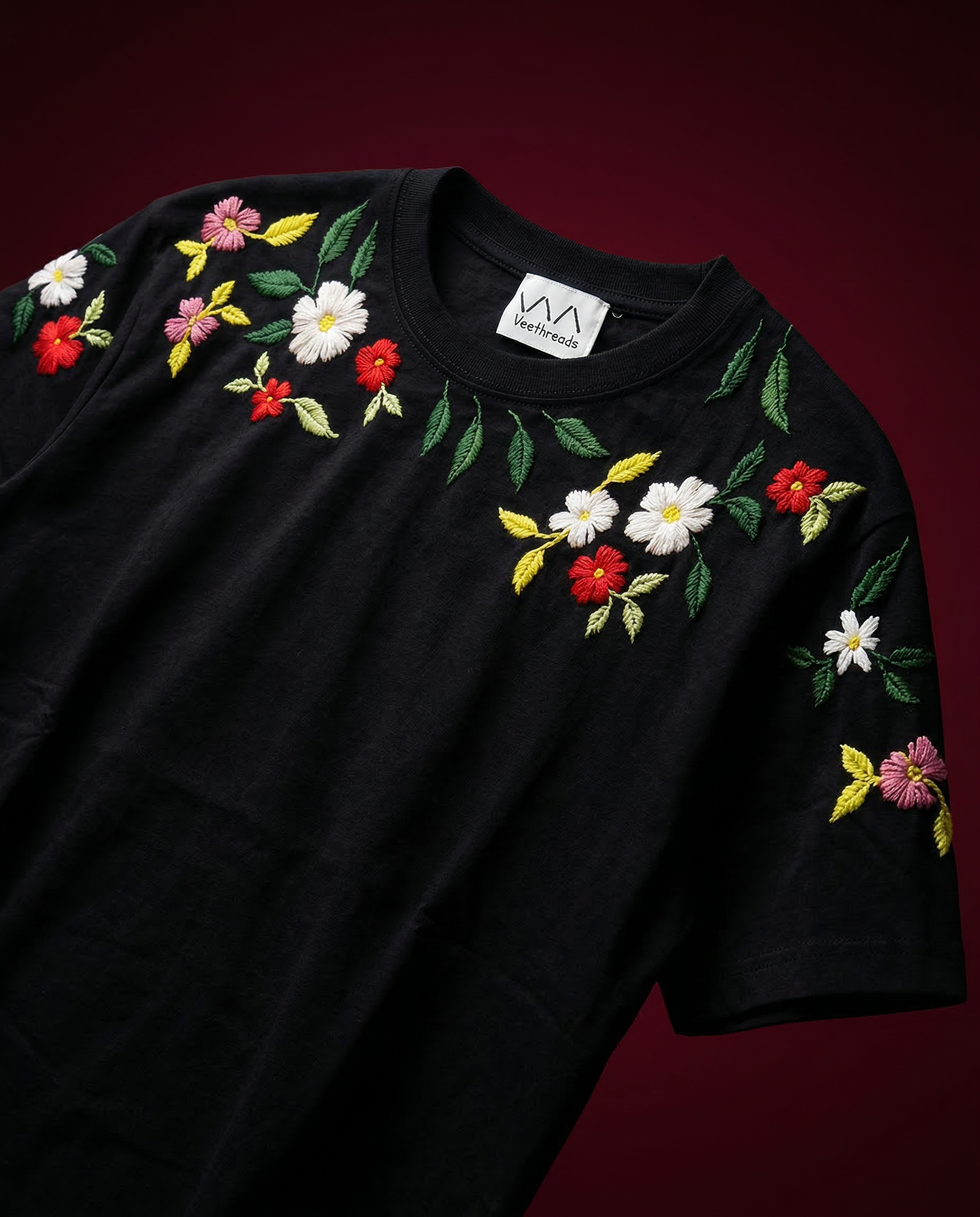 Black t-shirt with colorful floral embroidery on a dark background