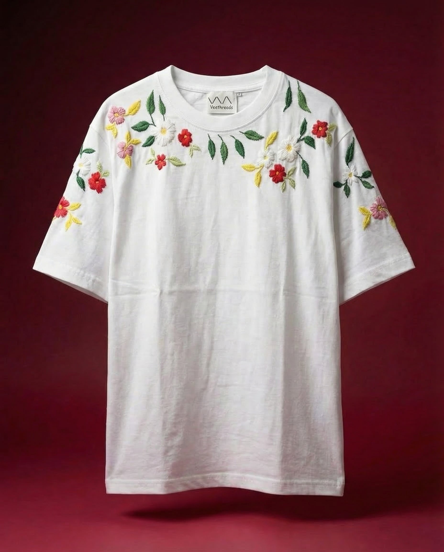 White t-shirt with floral embroidery on a red background