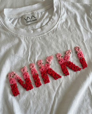 Custom name embroidered double-shade tee — white cotton tee with hand-embroidered floral text design in two thread shades, premium cotton