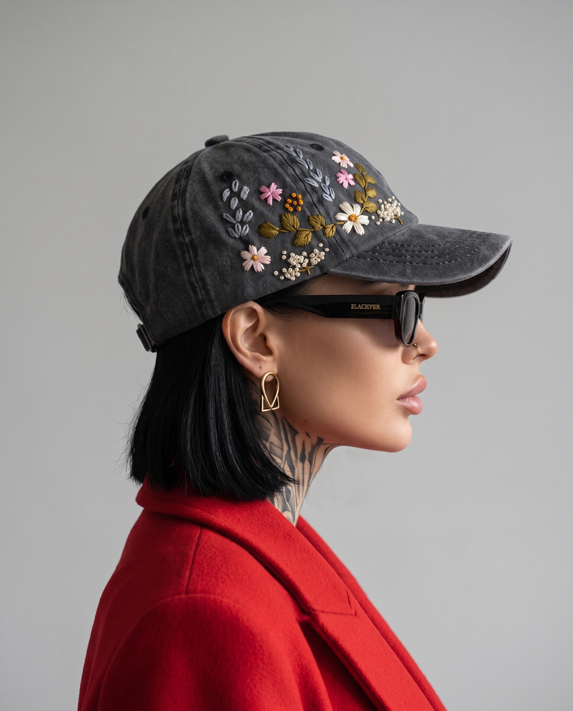 Side profile of model in Vee Threads floral hand-embroidered denim cap showing curved brim and stitched flowers