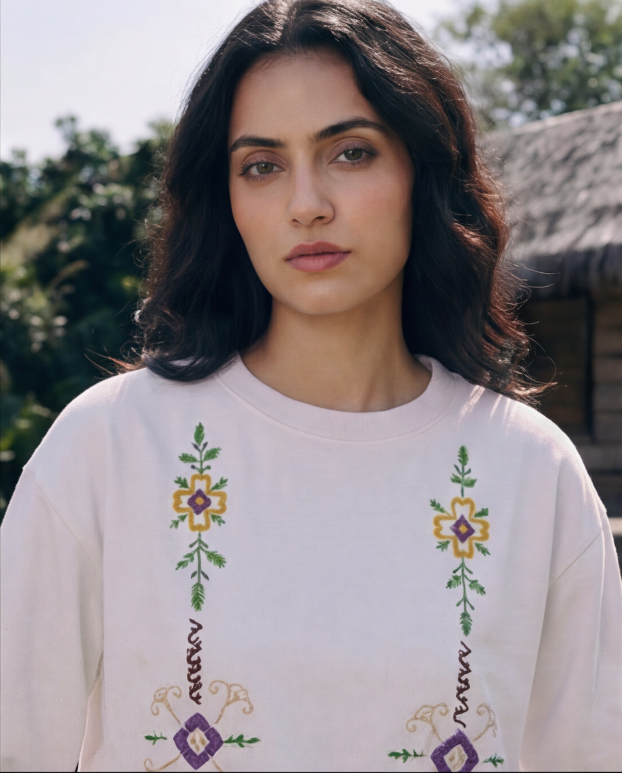 Woman wearing a white sweater with floral embroidery outdoors