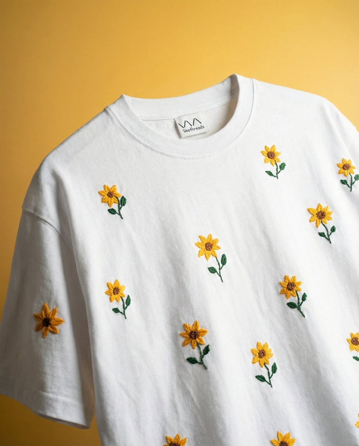 Sunflower embroidery on a shirt - hand-stitched yellow sunflowers across a white cotton tee