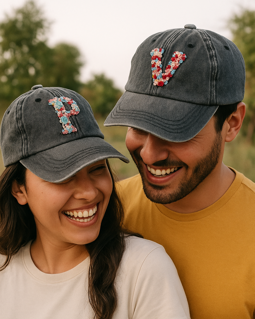 Two people wearing matching dark gray baseball caps with floral letter 'P' designs embroidered , standing outdoors.