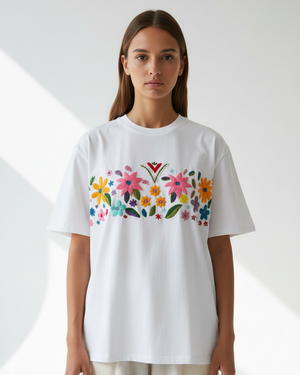 Person wearing a white t-shirt with colorful floral design on a white background