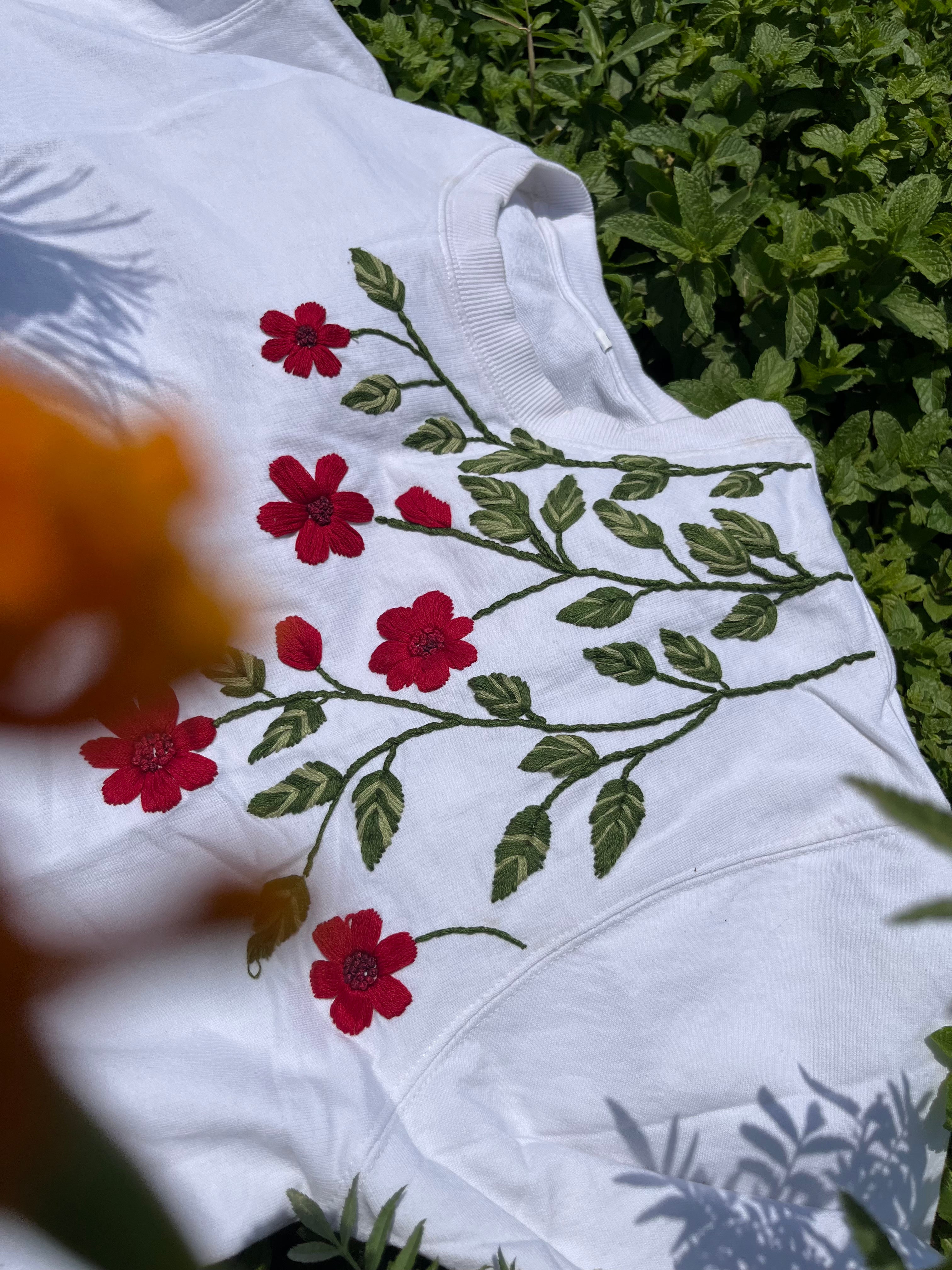 "Discover botanical elegance with our Scarlet Petal and Leaves hand-embroidered t-shirt. Vibrant scarlet petals and delicate leaves adorn this unisex masterpiece. Elevate your style with nature-inspired sophistication. Shop now!"