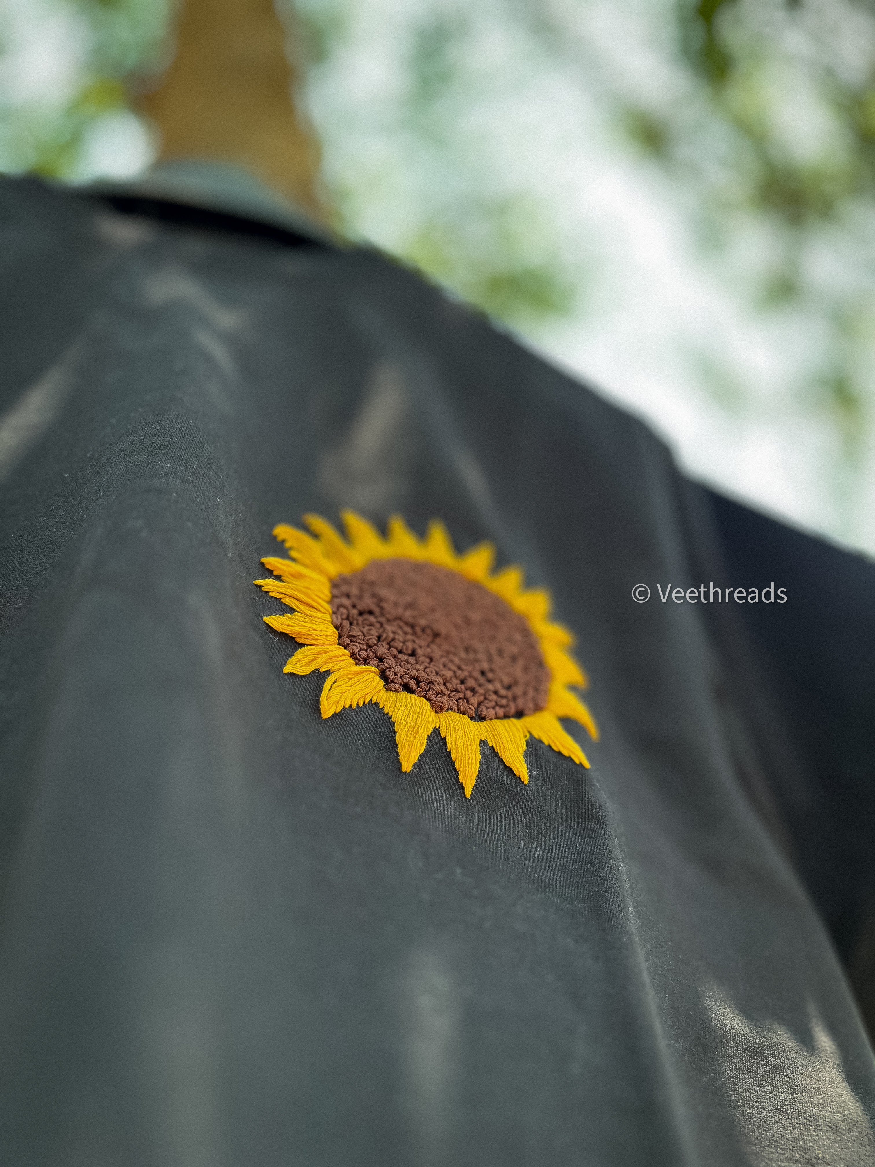 Stylish sunflower embroidery on a soft cotton t-shirt, perfect for casual wear and adding a touch of nature-inspired elegance.