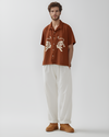 ust brown hand-embroidered men's shirt with Royal Bengal tiger design – sustainable artisan-made shirt styled with white pants, perfect for modern ethical fashion lovers.