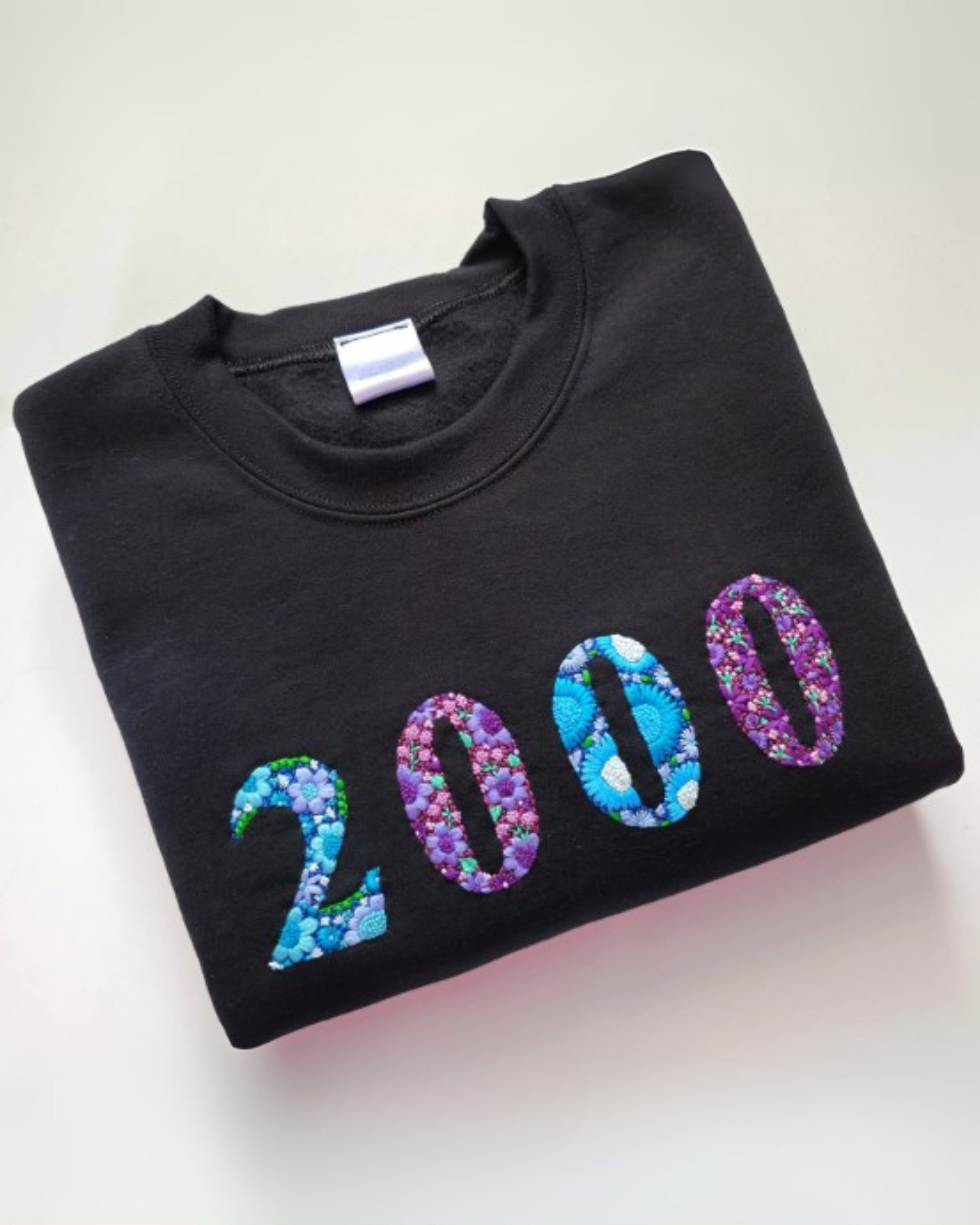 Flat lay showcasing handcrafted embroidery of year on premium cotton t-shirt