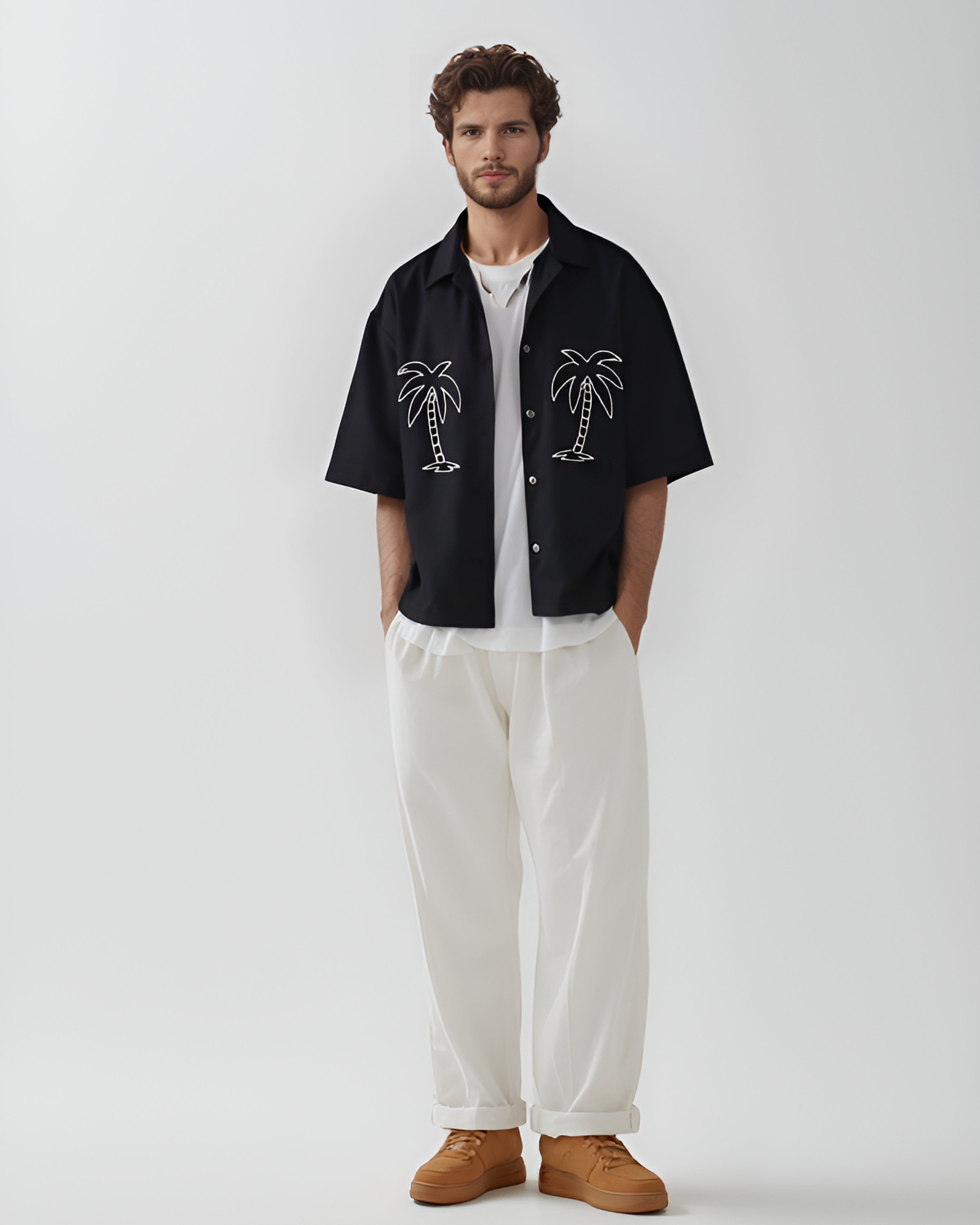 Black hand-embroidered men's shirt featuring minimalist white palm tree design – relaxed fit resortwear styled with white trousers, perfect for summer and beach-inspired fashion.