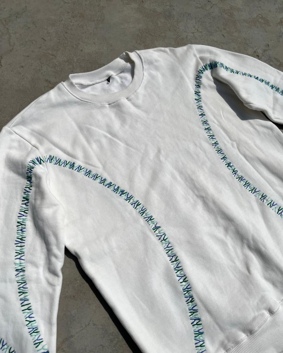 White long-sleeve shirt with blue text on a gray surface